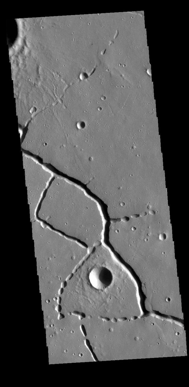 This VIS image is located in the northern portion of Hephaestus Fossae. Hephaestus Fossae is a complex channel system in Utopia Planitia near Elysium Mons. It has been proposed that the channels formed by the release of melted subsurface ice during the impact event that created a large crater southeast of this image. Additionally, the nearby Elysium volcanic center created subsurface heating that may have played a part in creating both Hephaestus Fossae and Hebrus Valles to the north. The right angle intersections indicate there is some tectonic activity in the region, and the circular depressions indicate surface collapse into subsurface voids. Hephaestus Fossae is a very complex set of features. Orbit Number: 88618 Latitude: 22.2991 Longitude: 121.441 Instrument: VIS Captured: 2021-12-06 02:47 https://photojournal.jpl.nasa.gov/catalog/PIA25199