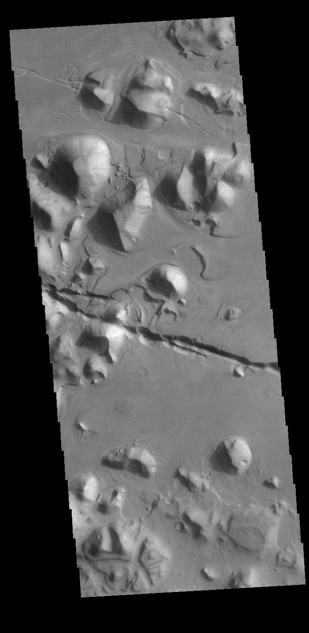 The linear depressions in the middle of this VIS image are graben called Cerberus Fossae. Graben form where extensional tectonic forces allows blocks of material to subside between paired faults. Cerberus Fossae are located in Elysium Planitia, southeast of the Elysium Mons volcanic complex. Orbit Number: 87793 Latitude: 15.3137 Longitude: 163.349 Instrument: VIS Captured: 2021-09-29 04:24 https://photojournal.jpl.nasa.gov/catalog/PIA25292
