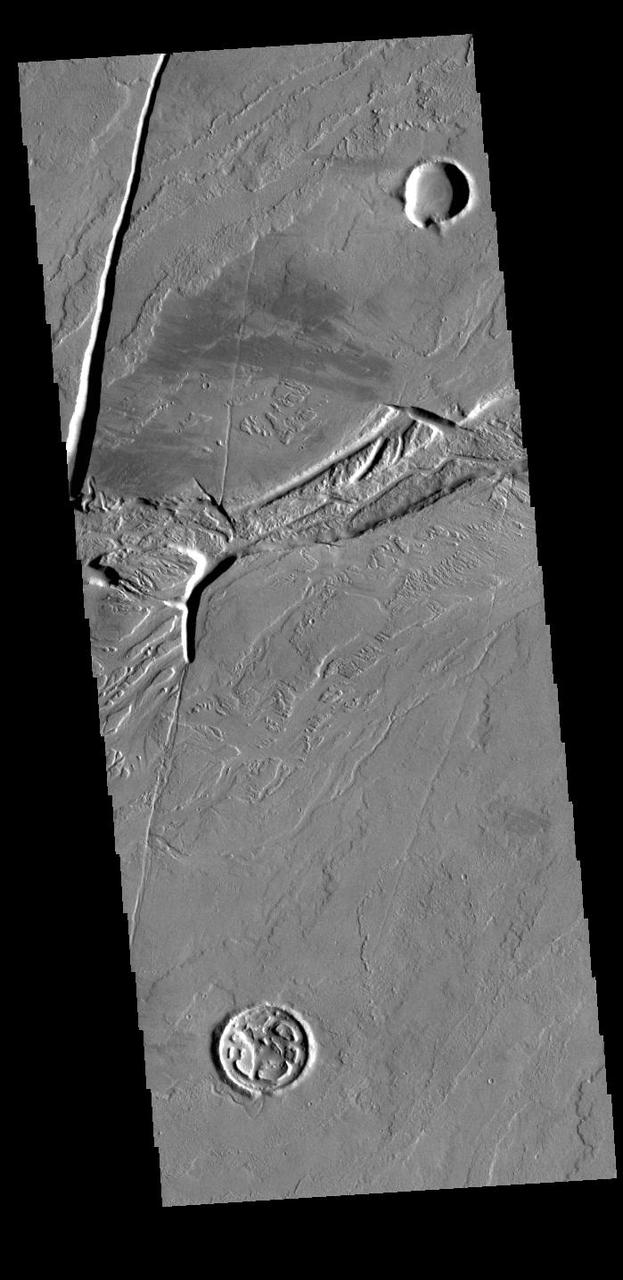 Olympica Fossae is a complex channel located on the volcanic plains between Alba Mons and Olympus Mons. It contains both linear sections that appear to be tectonic in origin and sinuous sections that were more likely created by liquid flow. Given the location it appears that lava, rather than water, was the fluid. Olympica Fossae 420km long (261 miles). Orbit Number: 88776 Latitude: 22.9121 Longitude: 243.053 Instrument: VIS Captured: 2021-12-19 03:01 https://photojournal.jpl.nasa.gov/catalog/PIA25302