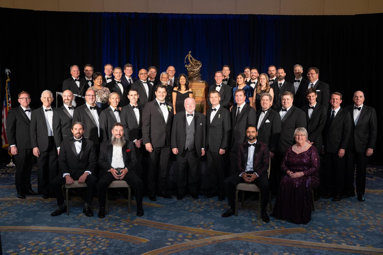 Members of NASA's Ingenuity Mars Helicopter team are pictured with the Collier Trophy during the Robert J. Collier Dinner in Washington on June 9, 2022. The team was awarded the 2021 Collier Trophy "for the first powered, controlled flight of an aircraft on another planet, thereby opening the skies of Mars and other worlds for future scientific discovery and exploration," the award citation states.  This historic trophy – which is on permanent display at the Smithsonian Air and Space Museum in Washington – is awarded annually by the National Aeronautic Association "for the greatest achievement in aeronautics or astronautics in America, with respect to improving the performance, efficiency, and safety of air or space vehicles, the value of which has been thoroughly demonstrated by actual use during the preceding year."  https://photojournal.jpl.nasa.gov/catalog/PIA25324