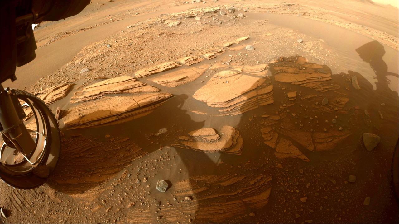 This image of the "Enchanted Lake" rocky outcrop, informally named after a landmark in Alaska's Katmai National Park and Preserve, was taken by one of the Hazard Avoidance Cameras (Hazcams) on NASA's Mars Perseverance rover on April 30, 2022, the 424th Martian day, or sol, of the mission. The image of the outcrop, near the base of Jezero Crater's delta, provided the rover science team with its first up-close glimpse of sedimentary rocks. Such rocks consist of fine particles carried by the atmosphere and/or water and deposited in generally flat-lying layers, which become indurated, or turned into rock, over time. A key objective for Perseverance's mission on Mars is astrobiology, including the search for signs of ancient microbial life. The rover will characterize the planet's geology and past climate, pave the way for human exploration of the Red Planet, and be the first mission to collect and cache Martian rock and regolith (broken rock and dust). Subsequent NASA missions, in cooperation with ESA (European Space Agency), would send spacecraft to Mars to collect these sealed samples from the surface and return them to Earth for in-depth analysis. The Mars 2020 Perseverance mission is part of NASA's Moon to Mars exploration approach, which includes Artemis missions to the Moon that will help prepare for human exploration of the Red Planet. https://photojournal.jpl.nasa.gov/catalog/PIA25325