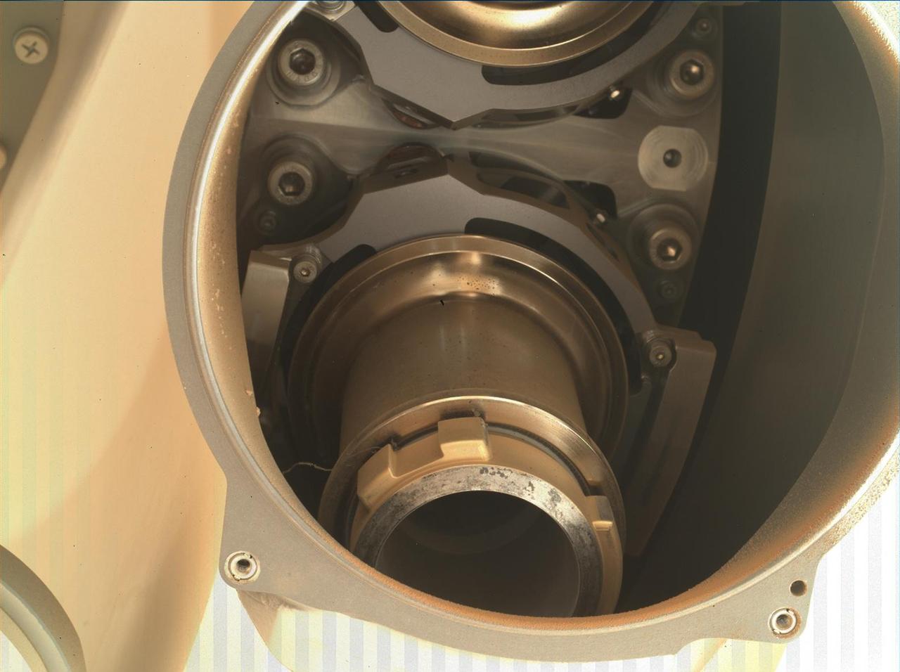 This image shows the back of Coring Bit 2 in the bit carousel of NASA's Perseverance Mars rover. A wavy, stringlike piece of foreign object debris (FOD) can be seen on the left side of the bit (the lower center of image). Coring Bit 2 was recently used to sample the sedimentary rock at "Wildcat Ridge." The image was obtained by the WATSON (Wide Angle Topographic Sensor for Operations and eNgineering) camera on Aug. 17, 2022, the 531st Martian day, or sol, of the mission. Located in the turret at the end of the rover's robotic arm, WATSON can document the structure and texture within a natural (intact), drilled, or abraded target, and its data can be used to derive depth measurements. The camera is a subsystem of the SHERLOC (Scanning Habitable Environments with Raman & Luminescence for Organics & Chemicals) instrument. NASA's Jet Propulsion Laboratory built and manages operations of Perseverance and Ingenuity for the agency. Caltech in Pasadena, California, manages JPL for NASA. WATSON was built by Malin Space Science Systems (MSSS) in San Diego and is operated jointly by MSSS and JPL. A key objective for Perseverance's mission on Mars is astrobiology, including the search for signs of ancient microbial life. The rover will characterize the planet's geology and past climate, pave the way for human exploration of the Red Planet, and be the first mission to collect and cache Martian rock and regolith (broken rock and dust). Subsequent NASA missions, in cooperation with ESA (European Space Agency), would send spacecraft to Mars to collect these sealed samples from the surface and return them to Earth for in-depth analysis. The Mars 2020 Perseverance mission is part of NASA's Moon to Mars exploration approach, which includes Artemis missions to the Moon that will help prepare for human exploration of the Red Planet. https://photojournal.jpl.nasa.gov/catalog/PIA25327