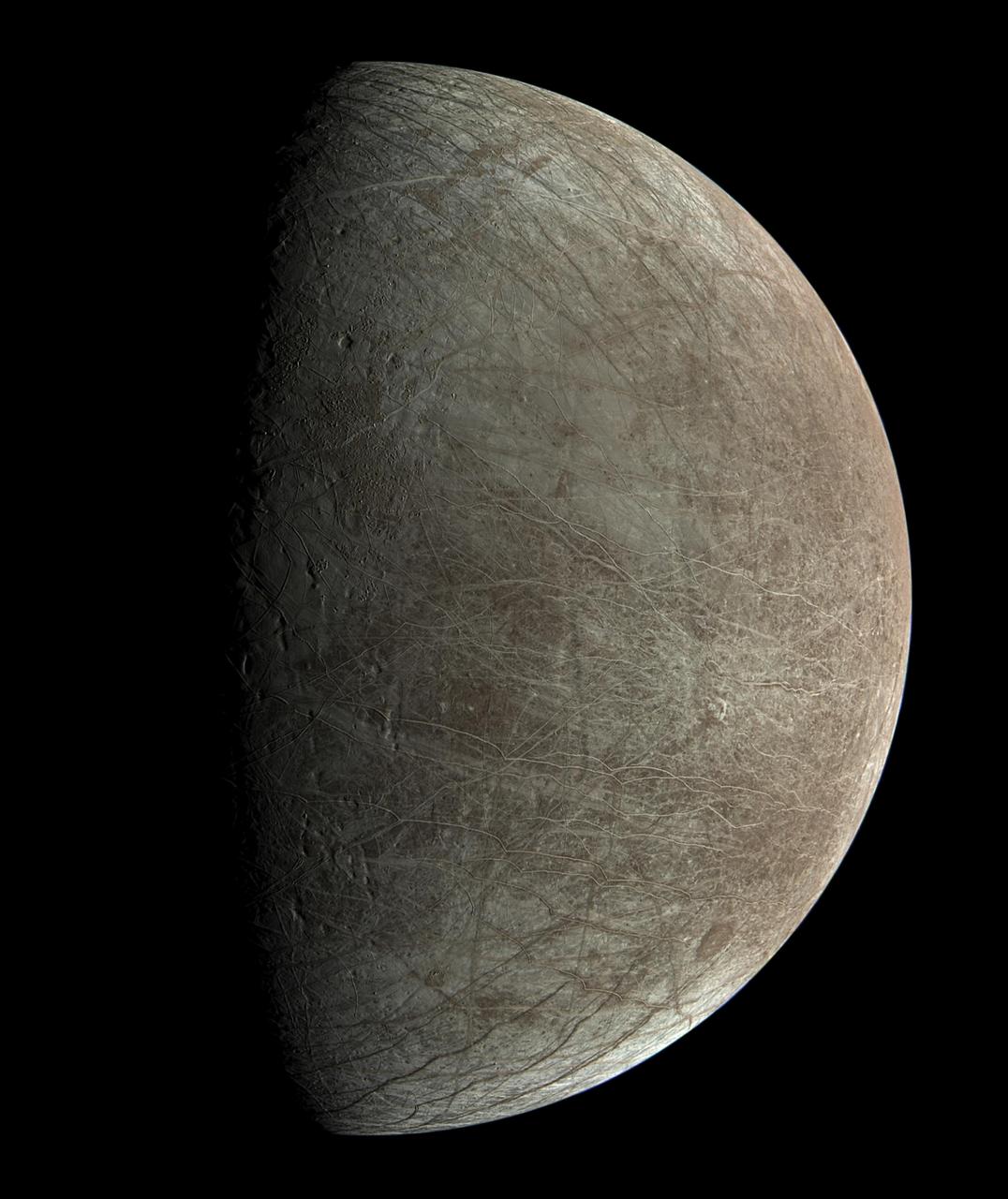This view of Jupiter's icy moon Europa was captured by JunoCam, the public engagement camera aboard NASA's Juno spacecraft, during the mission's close flyby on Sept. 29, 2022. Citizen scientist Björn Jónsson processed the view to create this image. Jónsson processed the image to enhance the color and contrast. The resolution is about 0.6 miles (1 kilometer) per pixel.  JunoCam took the image at an altitude of 945 miles (1,521 kilometers) above a region of the moon called Annwn Regio. In the image, terrain beside the day-night boundary is revealed to be rugged, with pits and troughs. Numerous bright and dark ridges and bands stretch across a fractured surface, revealing the tectonic stresses that the moon has endured over millennia. The circular dark feature at the lower right is Callanish Crater.  JunoCam images of Europa help fill in gaps in the maps from images obtained during by NASA's Voyager and Galileo missions.  In processing raw images taken by JunoCam, members of the public create deep-space portraits of the Jovian moon that aren't only awe-inspiring but also worthy of further scientific scrutiny. Juno citizen scientists have played an invaluable role in processing the numerous JunoCam images obtained during science operations at Jupiter.  https://photojournal.jpl.nasa.gov/catalog/PIA25334