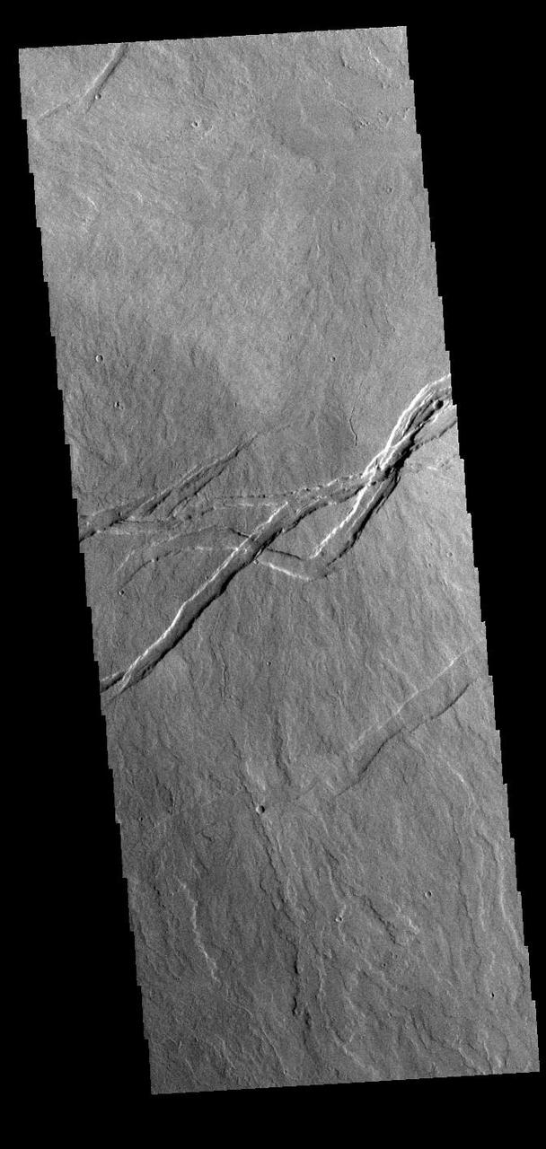 Today's VIS image shows volcanic flows and fractures between Arsia Mons and Pavonis Mons in the Tharsis volcanic region. The fractures – termed graben – follow the northeast/southwest trend of the three large Tharsis volcanoes.  Orbit Number: 89113 Latitude: -7.38183 Longitude: 244.754 Instrument: VIS Captured: 2022-01-15 20:50  https://photojournal.jpl.nasa.gov/catalog/PIA25348