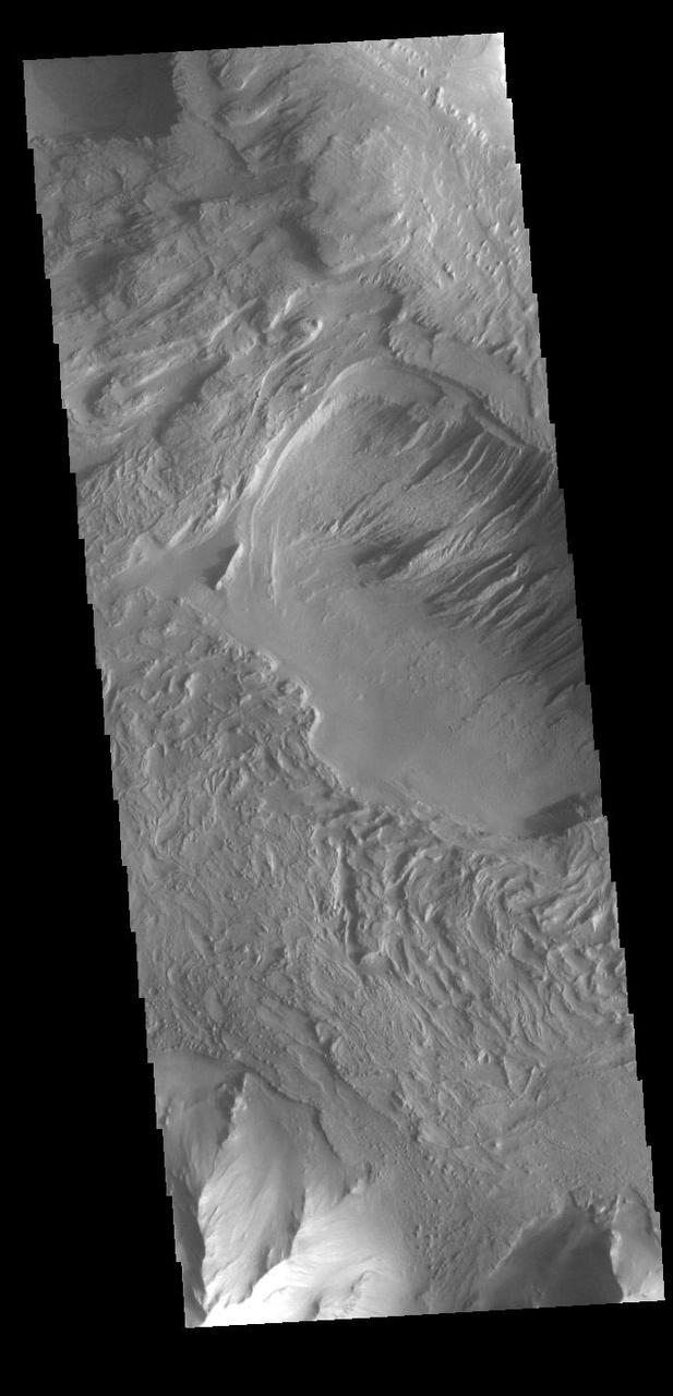 Today's VIS image shows part of the southern margin of Candor Chasma. While not as deep as the northern regions of eastern Candor Chasma, the southern region contains all the features seen at the lower elevations to the north. Candor Chasma is one of the largest canyons that make up Valles Marineris. It is approximately 810 km long (503 miles) and is divided into two regions - eastern and western Candor. Candor is located south of Ophir Chasma and north of Melas Chasma. The border with Melas Chasma contains many large landslide deposits. The floor of Candor Chasma includes a variety of landforms, including layered deposits, dunes, landslide deposits and steep sided cliffs and mesas. Many forms of erosion have shaped Candor Chasma. There is evidence of wind and water erosion, as well as significant gravity driven mass wasting (landslides).  Orbit Number: 89860 Latitude: -8.00834 Longitude: 293.829 Instrument: VIS Captured: 2022-03-18 09:02  https://photojournal.jpl.nasa.gov/catalog/PIA25398