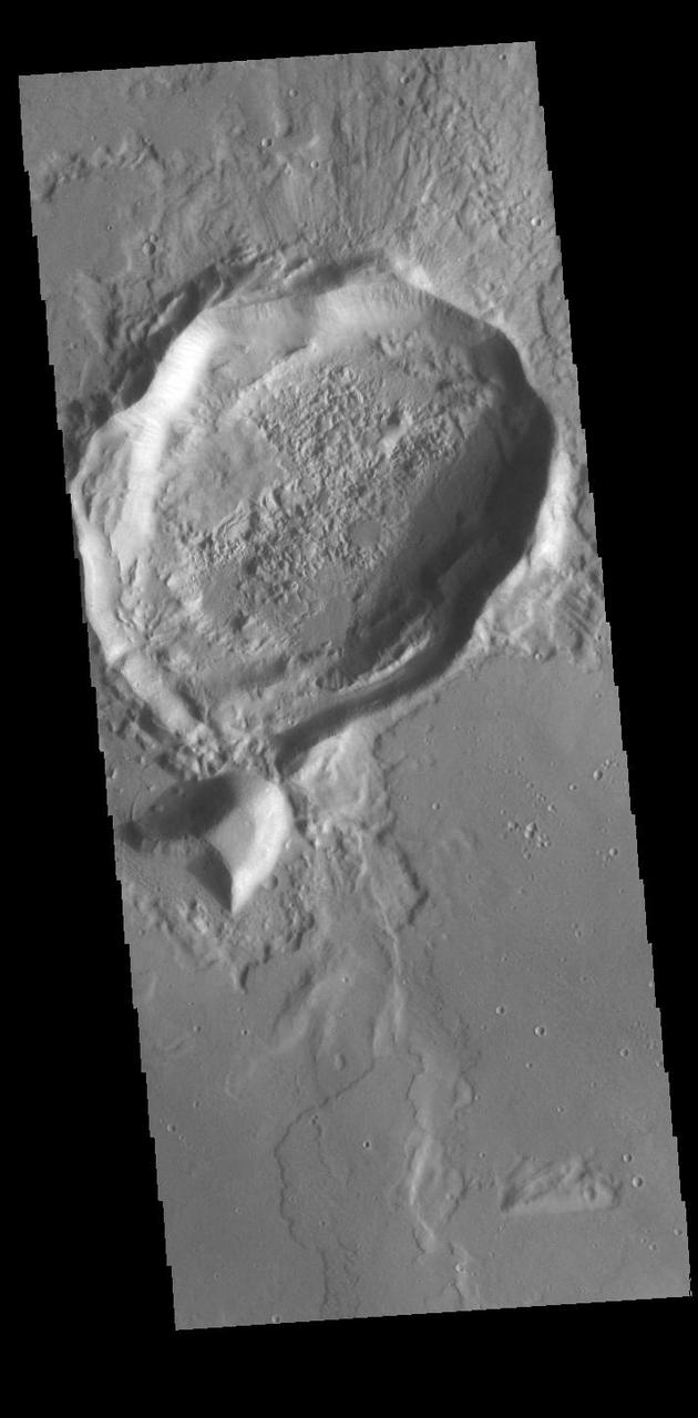 While the crater in this VIS image was crated by an impact event, the resultant form is not the normal circular shape. There are several factors that can create 'out of round' craters. The most common is subsurface faulting from tectonic activity. Pre-existing subsurface fractures can deflect impact pressures along the fault faces, rather than uniformly radially from the center of impact. Meteor Crater in Arizona has "corners" due to the same tectonic forcing of impact pressures. Orbit Number: 89615 Latitude: 31.7702 Longitude: 156.612 Instrument: VIS Captured: 2022-02-26 05:06 https://photojournal.jpl.nasa.gov/catalog/PIA25404