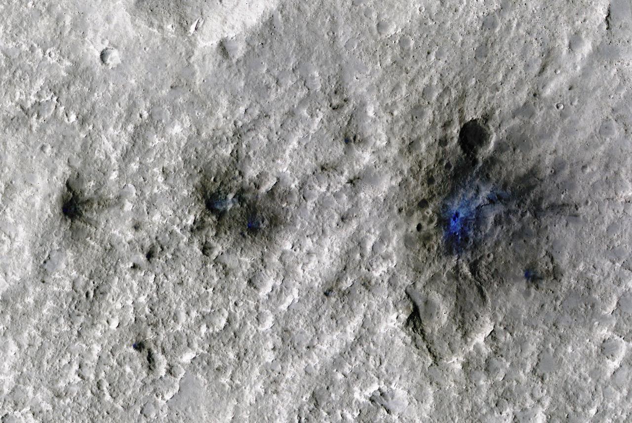 The craters seen here in blue were formed by a meteoroid impact on Mars on Sept. 5, 2021. The impact was the first to be detected by NASA's InSight mission; the image was taken later by NASA's Mars Reconnaissance Orbiter using its High Resolution Imaging Science Experiment (HiRISE) camera.  The initial impact itself created a small marsquake that was detected by InSight's seismometer. The instrument recorded seismological data that showed the moment the meteoroid entered Mars' atmosphere, its explosion into pieces in the atmosphere, and finally, the impact that created a series of at least three craters in the surface.  MRO then flew over the approximate site where the impact was "felt" to look for darkened patches of ground using its Context Camera. After finding this location, HiRISE captured the scene in color. The ground is not actually blue; this enhanced-color image highlights certain hues in the scene to make details more visible to the human eye – in this case, dust and soil disturbed by the impact.  https://photojournal.jpl.nasa.gov/catalog/PIA25408