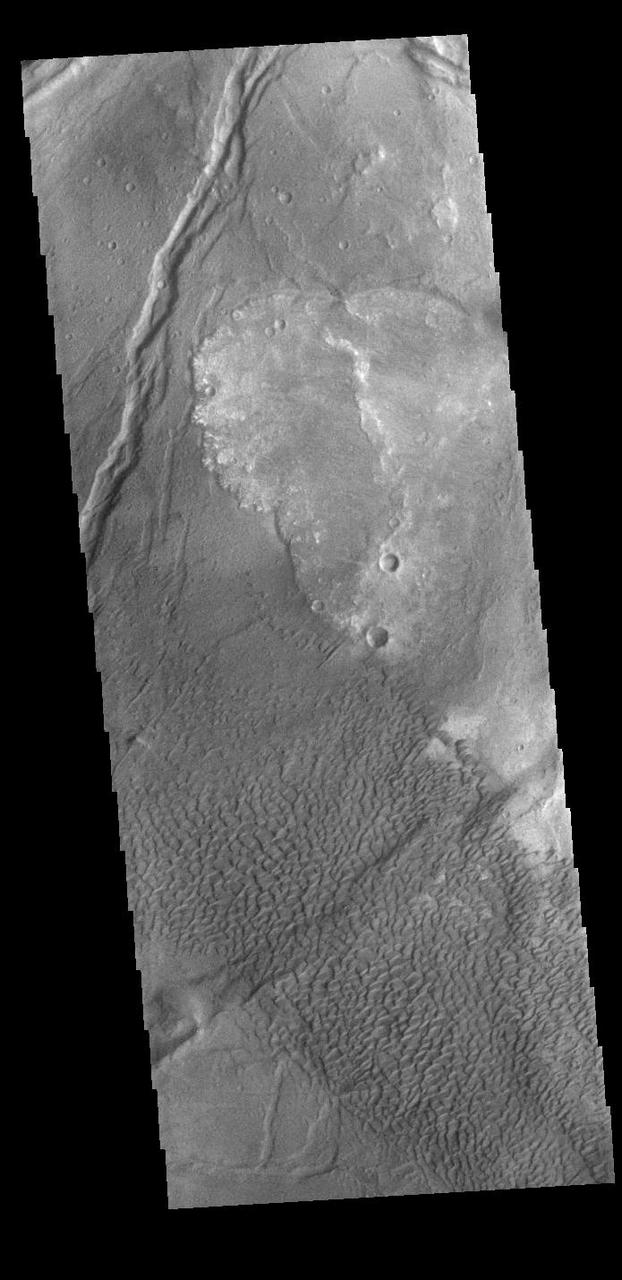 Today's VIS image shows part of Nili Patera. Nili Patera is the northern caldera in the immense volcanic complex of Syrtis Major Planum. The dunes are moving westward across the top of these ancient volcanic flows. Orbit Number: 90030 Latitude: 8.95316 Longitude: 67.1774 Instrument: VIS Captured: 2022-04-01 09:05 https://photojournal.jpl.nasa.gov/catalog/PIA25468
