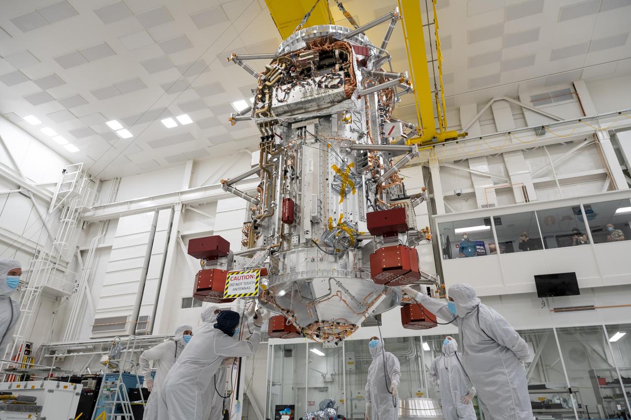 Engineers and technicians use a crane to lift the main body of NASA's Europa Clipper spacecraft and position it in the High Bay 1 clean room of the Spacecraft Assembly Facility at the agency's Jet Propulsion Laboratory in Southern California. Standing 10 feet (3 meters) high and 5 feet (1.5 meters) wide, the core will be the focus of attention as the spacecraft is assembled for its launch to Jupiter's moon Europa in October 2024.  Europa Clipper will conduct nearly 50 flybys of the icy Jovian moon Europa, which scientists are confident harbors an internal ocean containing twice as much water as Earth's oceans combined. The moon may currently have conditions suitable for supporting life. The spacecraft's nine science instruments, plus a gravity science investigation, will gather data on the moon's atmosphere, surface, and interior – information that scientists will use to gauge the depth and salinity of the ocean, the thickness of the ice crust, and potential plumes that may be venting subsurface water into space.  https://photojournal.jpl.nasa.gov/catalog/PIA25491