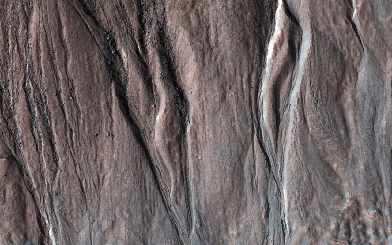 This image shows (part of) a 6-kilometer crater located on the northern slope of Bond Crater. Pole-facing gullies have eroded the northern slope of this small crater, located just west of where Uzboi Valles emanates from Bond and continues in a northerly direction.  However, Hale Crater to the south has numerous gullies on its slopes and even on its central peak region. Researchers have analyzed both Bond and Hale Craters to try to determine why Bond has no gullies on its slopes, except for a small 7-km crater on the floor in its central area. (Reiss et al., 2009, PSS).  The gullies in this observation have eroded into bedrock layers forming tributaries in the upper slope region and distributary channels further downslope on the debris fans. Research attributes these features to fluvial processes. (Gulick et al., 2018, Geol. Soc. London.)  https://photojournal.jpl.nasa.gov/catalog/PIA25504