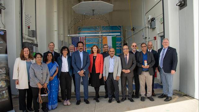 Officials from NASA, the Indian Space Research Organization (ISRO), and the Embassy of India hold a send-off ceremony for the NASA-ISRO Synthetic Aperture Radar (NISAR) science instrument payload on Feb. 3, 2023, outside a clean room at NASA's Jet Propulsion Laboratory in Southern California. The payload is scheduled to be shipped to India in March. Pictured left to right: Karen St. Germain, director, Earth Science Division, NASA; Mitra Dutta, NISAR program executive, NASA; Sripriya Ranganathan, ambassador and deputy chief of mission, Indian Embassy; Larry James, deputy director, JPL; Bhavya Lal, associate administrator for technology, policy, and strategy, NASA; Jim Graf, director, Earth Science and Technology Directorate, JPL; S. Somanath, chairman, ISRO; Laurie Leshin, director, JPL; Krunal Joshi, counselor, space and ISRO technical liaison officer, Indian Embassy; M. Sankaran, director, U R Rao Satellite Centre, ISRO; Shantanu Bhatawdekar, scientific secretary, ISRO; Paul Rosen, NISAR project scientist, JPL; CV Shrikant, NISAR project director, ISRO; Phil Barela, NISAR project manager, JPL; and Gerald Bawden, NISAR program scientist, NASA. NISAR – a joint effort between NASA and ISRO – will measure changes to Earth's land ice surfaces down to fractions of an inch. Data collected by this satellite will help researchers monitor a wide range of changes critical to life on Earth in unprecedented detail. This includes spotting warning signs of imminent volcanic eruptions, helping to monitor groundwater supplies, tracking the melt rate of ice sheets tied to sea level rise, and observing shifts in the distribution of vegetation around the world. The data will inform humanity's responses to urgent challenges posed by natural disasters and climate change, and help communities prepare for and manage hazards. There are two instruments on the satellite that will send and receive radar signals to and from Earth's surface to make the mission's measurements. An L-band synthetic aperture radar (SAR), which uses a signal wavelength of around 9 inches (24 centimeters), and an S-band SAR with a signal wavelength of nearly 5 inches (12 centimeters). Both will bounce their microwave signal off of the planet's surface and record how long it takes the signal to make one roundtrip, as well as the strength of that return signal. This enables the researchers to calculate the distance from the spacecraft to Earth's surface and thereby determine how the land or ice is changing. An antenna reflector nearly 40 feet (12 meters) in diameter, supported by a deployable boom, will focus the microwave signals sent and received by the SARs. JPL, which is managed for NASA by Caltech in Pasadena, leads the U.S. component of NISAR and is providing the mission's L-band SAR instrument. NASA is also providing the radar reflector antenna, the deployable boom, a high-rate communication subsystem for science data, GPS receivers, a solid-state recorder, and payload data subsystem. ISRO is providing the spacecraft bus, the S-band SAR, the launch vehicle, and associated launch services and satellite mission operations. https://photojournal.jpl.nasa.gov/catalog/PIA25600
