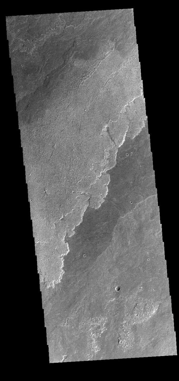 Today's VIS image shows a small portion of the immense lava flows that originated from Arsia Mons. Arsia Mons is the southernmost of the three large aligned volcanoes in the Tharsis region. Arsia Mons' last eruption was 10s of million years ago. The different surface textures are created by differences in the lava viscosity and cooling rates. The lobate margins of each flow can be traced back to the start of each flow — or to the point where they are covered by younger flows. Flows in Daedalia Planum can be as long as 180 km (111 miles). For comparison the longest Hawaiian lava flow is only 51 km (˜31 miles) long. The total area of Daedalia Planum is 2.9 million square km – more than four times the size of Texas. Orbit Number: 91559 Latitude: -22.1397 Longitude: 240.149 Instrument: VIS Captured: 2022-08-05 06:28 https://photojournal.jpl.nasa.gov/catalog/PIA25605
