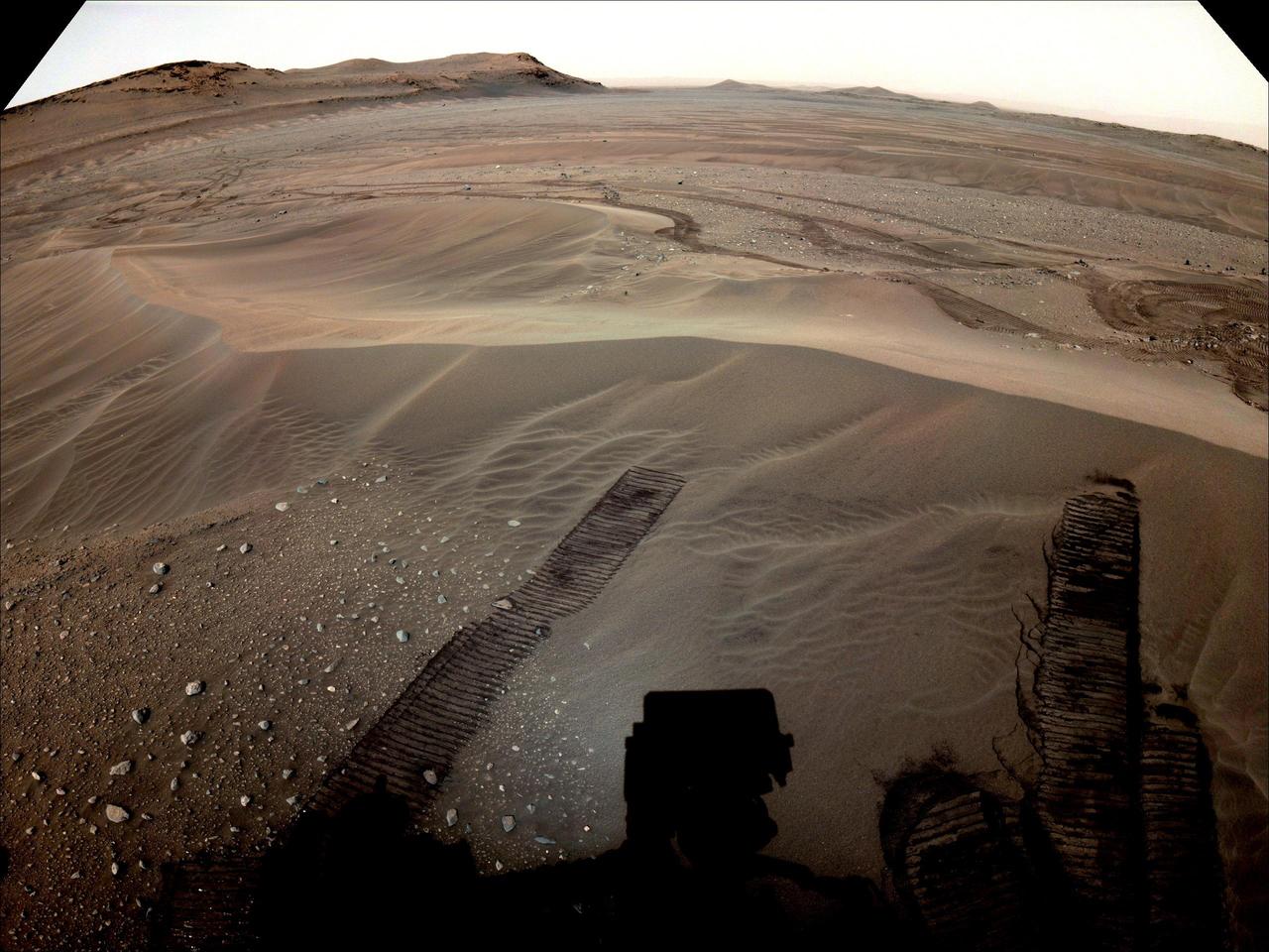 The location where NASA's Perseverance will begin depositing its first cache of samples is shown in this image taken by the Mars rover on Dec. 14, 2022, the 646th Martian day, or sol, of the mission. This enhanced color image was taken by the rover's Mastcam-Z camera and is not representative of the way the scene would look to the human eye.  A key objective for Perseverance's mission on Mars is astrobiology, including the search for signs of ancient microbial life. The rover will characterize the planet's geology and past climate, pave the way for human exploration of the Red Planet, and be the first mission to collect and cache Martian rock and regolith (broken rock and dust).  Subsequent NASA missions, in cooperation with ESA (European Space Agency), would send spacecraft to Mars to collect these sealed samples from the surface and return them to Earth for in-depth analysis.  The Mars 2020 Perseverance mission is part of NASA's Moon to Mars exploration approach, which includes Artemis missions to the Moon that will help prepare for human exploration of the Red Planet.  https://photojournal.jpl.nasa.gov/catalog/PIA25675