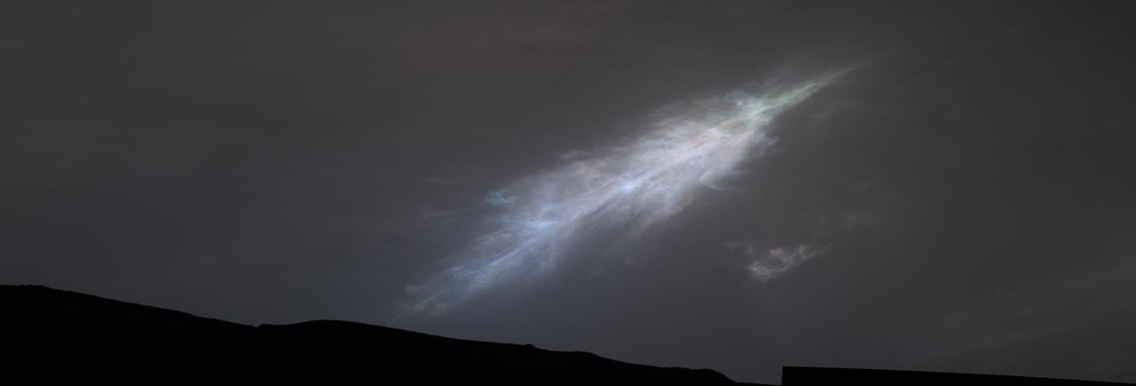 NASA's Curiosity Mars rover captured this feather-shaped iridescent cloud just after sunset on Jan. 27, 2023, the 3,724th Martian day, or sol, of the mission. Studying the colors in iridescent clouds tells scientists something about particle size within the clouds and how they grow over time. These clouds were captured as part of a follow-on imaging campaign to study noctilucent, or "night-shining" clouds, which started in 2021. While most Martian clouds hover no more than 37 miles (60 kilometers) above the ground and are composed of water ice, these clouds appear to be higher in elevation, where it's very cold. That suggests these clouds are made of carbon dioxide, or dry ice. This scene made up of 28 individual images captured by the rover's Mast Camera, or Mastcam. The images have been processed to emphasize the highlights. https://photojournal.jpl.nasa.gov/catalog/PIA25740
