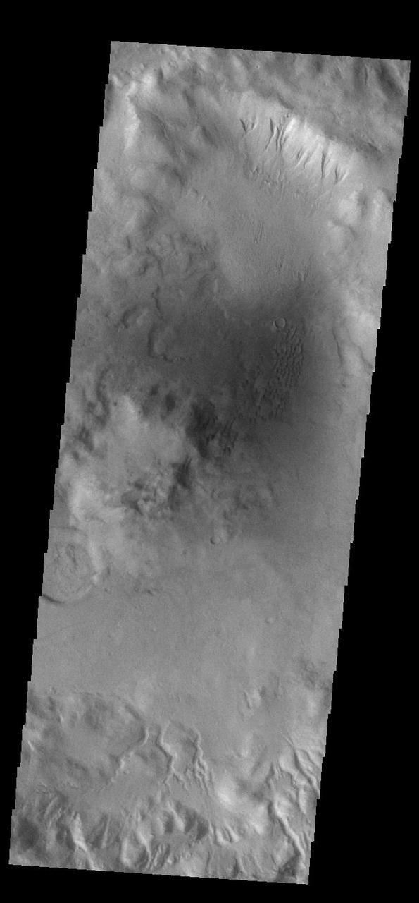 This VIS image shows part of the rim of an unnamed crater in Terra Sirenum. A group of channels dissect the rim in the center of the image. These channels are called gullies due to being on a steep slope rather than a flat river plain. In some images it is possible to see a boundary layer between the upper incised gully and a lower deposition region. The boundary marks a change in slope, the steep upper portion supports fast moving fluid that carves into the rim eroding materials. The change to a flatter slope causes the fluid to slow down and as it slows the materials carried by the fluid are deposited. Orbit Number: 92428 Latitude: -44.183 Longitude: 194.798 Instrument: VIS Captured: 2022-10-15 19:08 https://photojournal.jpl.nasa.gov/catalog/PIA25761