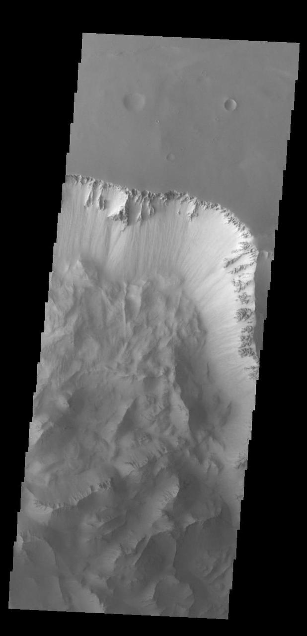 Today's VIS image shows part of Ius Chasma. Ius Chasma is at the western end of Valles Marineris. Valles Marineris is over 4000 kilometers long, wider than the United States. Ius Chasma is almost 850 kilometers long (528 miles), 120 kilometers wide and over 8 kilometers deep. In comparison, the Grand Canyon in Arizona is about 175 kilometers long, 30 kilometers wide, and only 2 kilometers deep. The canyons of Valles Marineris were formed by extensive fracturing and pulling apart of the crust during the uplift of the vast Tharsis plateau. Landslides have enlarged the canyon walls and created deposits on the canyon floor. Weathering of the surface and influx of dust and sand have modified the canyon floor, both creating and modifying layered materials. There are many features that indicate flowing and standing water played a part in the chasma formation. The rugged floor of Ius Chasma in this image is the result of many large landslides.  Orbit Number: 92987 Latitude: -6.37421 Longitude: 273.45 Instrument: VIS Captured: 2022-11-30 19:36  https://photojournal.jpl.nasa.gov/catalog/PIA25808
