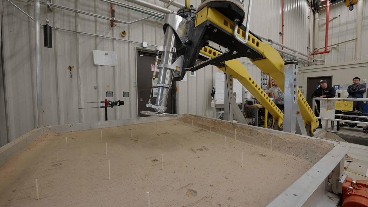      This setup is being used at NASA's Jet Propulsion Laboratory to test a 16-inch-diameter (40-centimeter-diameter) footpad for a future Mars lander. The footpad was plunged into a test bed filled with 10,000 pounds (4,536 kilograms) of simulated Martian soil in order to see how deep it would sink – too far, and the lander's belly could scrape against the ground during touchdown, damaging it.      The Sample Retrieval Lander, which would be central to NASA's Mars Sample Return campaign, is estimated to weigh as much as 5,016 pounds (2,275 kilograms). It would be the heaviest spacecraft ever to land on the Red Planet. In order to understand how energy would be absorbed during the landing of such a massive spacecraft, JPL engineers have been conducting drop tests of a full-size footpad.      Mars Sample Return will revolutionize our understanding of Mars by bringing scientifically selected samples to Earth for study using the most sophisticated instrumentation around the world. NASA's planned Mars Sample Return (MSR) campaign would fulfill one of the highest priority solar system exploration goals identified by the National Academies of Sciences, Engineering and Medicine in the past three decadal surveys. This strategic partnership with the ESA (European Space Agency) features the first mission to return samples from another planet, including the first launch from the surface of another planet. The samples being collected by NASA's Perseverance rover during its exploration of an ancient river delta are thought to be the best opportunity to reveal the early evolution of Mars, including the potential for ancient life.  https://photojournal.jpl.nasa.gov/catalog/PIA25824