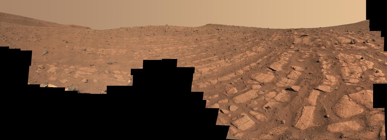 Scientists think that the bands of rocks seen in this image may have been formed by a very fast, deep river – the first of its kind evidence has been found for on Mars. NASA's Perseverance Mars rover captured this mosaic at a location nicknamed "Skrinkle Haven" using its Mastcam-Z camera between Feb. 28 and March 9, 2023 (between the 721st and 729th Martian days, or sols, of the mission). The mosaic is made up of 203 individual images that were stitched together after being sent back from Mars. This natural color view is approximately how the scene would appear to an average person if they were on Mars. "Skrinkle Haven" offers the clearest example of these curved rock layers – called "the curvilinear unit" – that had previously only been seen from space. Scientists are now debating what kind of powerfully flowing water formed those curves: a river like the Mississippi, which winds snakelike across the landscape, or a braided river like Nebraska's Platte, which forms small islands of sediment called sandbars. When viewed from the ground, the curved layers are arranged in rows, and appear to ripple out across the landscape. They could be the remnants of a river's banks that shifted over time – or the remnants of sandbars that formed in the river. The layers were likely much taller in the past; scientists suspect that after these piles of sediment turned to rock, they were sand-blasted by wind over the course of eons and carved down to their present size. Arizona State University leads the operations of the Mastcam-Z instrument, working in collaboration with Malin Space Science Systems in San Diego, on the design, fabrication, testing, and operation of the cameras, and in collaboration with the Niels Bohr Institute of the University of Copenhagen on the design, fabrication, and testing of the calibration targets. A key objective for Perseverance's mission on Mars is astrobiology, including the search for signs of ancient microbial life. The rover will characterize the planet's geology and past climate, pave the way for human exploration of the Red Planet, and be the first mission to collect and cache Martian rock and regolith (broken rock and dust). Subsequent NASA missions, in cooperation with ESA (European Space Agency), would send spacecraft to Mars to collect these sealed samples from the surface and return them to Earth for in-depth analysis. The Mars 2020 Perseverance mission is part of NASA's Moon to Mars exploration approach, which includes Artemis missions to the Moon that will help prepare for human exploration of the Red Planet. https://photojournal.jpl.nasa.gov/catalog/PIA25829