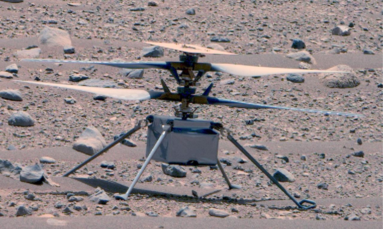 This enhanced color image of NASA's Ingenuity Mars Helicopter was taken by the Mastcam-Z instrument aboard Perseverance on April 16, 2023, the 766th Martian day, or sol, of the rover's mission. At the time the image was taken, the rover was about 75 feet (23 meters) away. The helicopter's first flight on Mars was on April 19, 2021.  This is the best look the Ingenuity team has had of the rotorcraft since its first flight.  Small diodes (visible more clearly in this image of helicopter) appear as small protrusions on the top of the helicopter's solar panel. The panel and the two 4-foot (1.2-meter) counter-rotating rotors have accumulated a fine coating of dust. The metalized insulating film covering the exterior of the helicopter's fuselage appears to be intact. Ingenuity's color, 13-megapixel, horizon-facing terrain camera can be seen at the center-bottom of the fuselage.  https://photojournal.jpl.nasa.gov/catalog/PIA25881