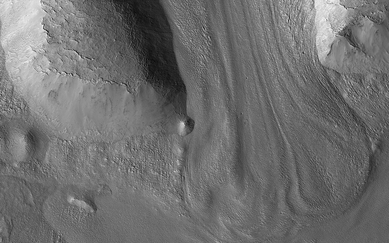 There are many locations in the mid-latitudes of Mars that look like material has flowed. This image shows an example flowing downhill between two ridges. Comparing these to what we see on the Earth and to other information we have about Mars leads scientists to believe that these are glaciers. Glacier-like features like this indicate that ice accumulated here in the past, which does not happen in today's climate. It's somewhat of a mystery why these features have flowed so much when they are so thin, the ice is so cold, and Martian gravity is so low. They probably move much more slowly than typical glaciers on Earth, but Mars has plenty of time on its hands so they end up looking very similar to the valley glaciers we see on our own planet. https://photojournal.jpl.nasa.gov/catalog/PIA25947