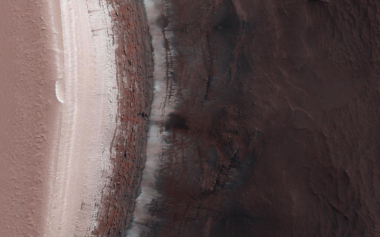 An ice cap about three kilometers (two miles) thick exists at the North Pole of Mars. In some locations its edge is a cliff about 800 meters (half a mile) high that is an almost-vertical wall of ice.  With HiRISE images like this one we can look at this cliff face and see it is broken up into jagged blocks. Debris piles at the base of the cliff show where these blocks have fallen out.  In the spring, we also sometimes see avalanches pouring down these cliff faces and this image was taken to search for more of them. No avalanches are visible this time., however. For reasons we don't understand, the number of avalanches varies from year to year and this spring appears to be a low-avalanche year.  https://photojournal.jpl.nasa.gov/catalog/PIA25949