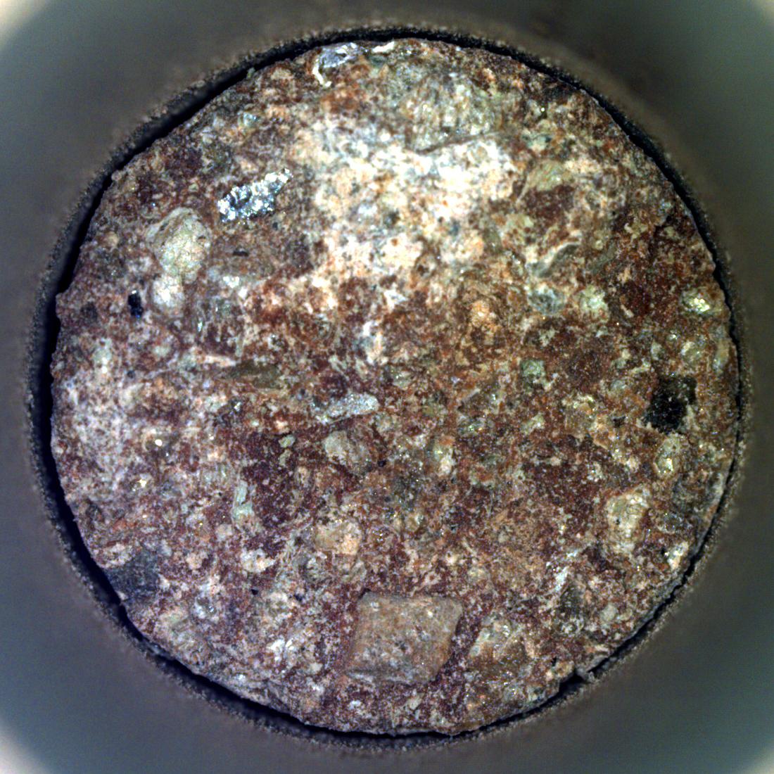 NASA's Perseverance Mars rover captured this image of a rock core nicknamed "Otis Peak" on June 12, 2023, the 822nd day, or sol, of the mission. The image shows the bottom of the Otis Peak core, which was collected from a conglomerate rock called "Emerald Lake." The distinctly colored areas are individual minerals (or rock fragments) transported by the river that once flowed into Mars' Jezero Crater.  The image was taken by Perseverance's Sampling and Caching System Camera, or CacheCam, located inside the rover underbelly. The camera looks down into the top of a sample tube to take close-up pictures of the sampled material and the tube as it's prepared for sealing and storage.  A key objective for Perseverance's mission on Mars is astrobiology, including the search for signs of ancient microbial life. The rover will characterize the planet's geology and past climate, pave the way for human exploration of the Red Planet, and be the first mission to collect and cache Martian rock and regolith (broken rock and dust).  Subsequent NASA missions, in cooperation with ESA (European Space Agency), would send spacecraft to Mars to collect these sealed samples from the surface and return them to Earth for in-depth analysis.  The Mars 2020 Perseverance mission is part of NASA's Moon to Mars exploration approach, which includes Artemis missions to the Moon that will help prepare for human exploration of the Red Planet.  https://photojournal.jpl.nasa.gov/catalog/PIA25962