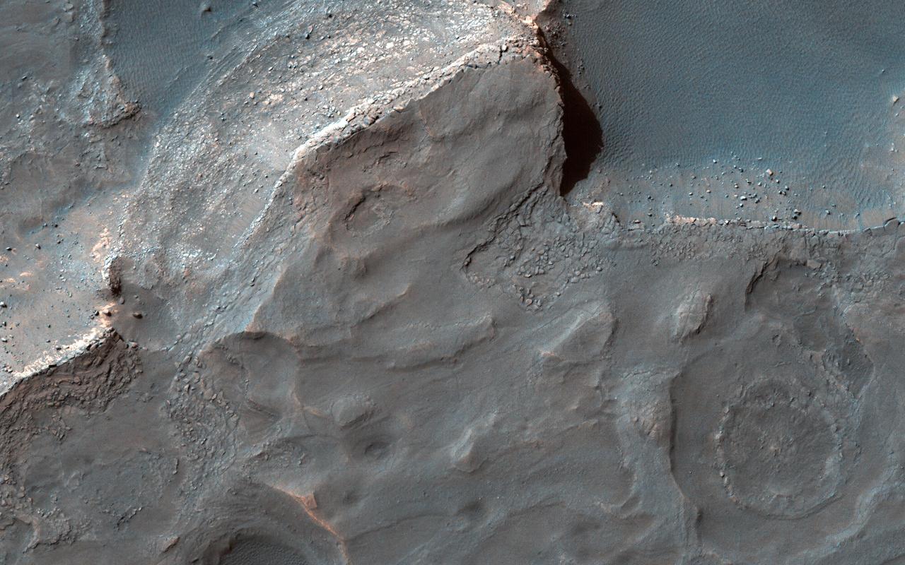 Gale Crater is well-known as the landing site of NASA's Curiosity rover, which has explored the northwest crater floor since 2012. But the entire crater is full of fascinating geology, some beyond the rover's reach.  This image covers a fan of sedimentary rock on the southeast crater floor. Ridges on the fan surface may be composed of coarse-grained sediment deposited in ancient streams. More recent wind erosion of the surrounding finer sediments could have left these channel deposits elevated in "inverted relief." A closeup shows some of these ridges, as well as light-toned layers of sediment exposed along the fan edge.  The fan is also punctured by scattered circular impact craters. One of these craters appears to have a circular deposit of sedimentary rock filling its floor, suggesting that it formed during the span of time that streams were active here. Features like this help scientists to infer the geologic history of the region.  https://photojournal.jpl.nasa.gov/catalog/PIA25988
