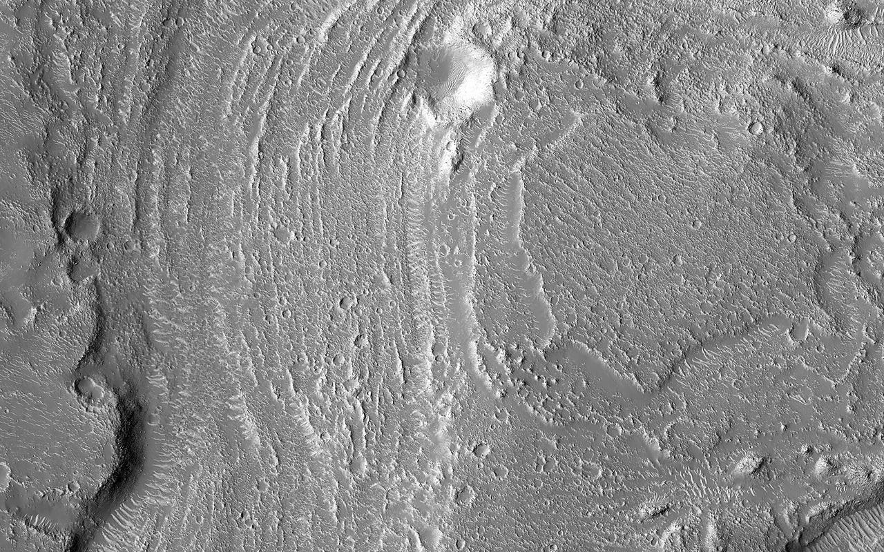 Granicus Valles form a low-lying complex of channel systems located west of the volcano Elysium Mons. They are one of several larger systems known as outflow channels because the water source is from the subsurface. In this case, Granicus Valles emanate from a series of fractures on the western flank of Elysium Mons. In this image, large, streamlined features and grooves have been carved by enormous water volumes into the floor of Granicus and point to the direction of flow towards the northwest. The floods of Granicus Valles are thought to have formed later in Mars history during the Amazonian epoch, several billion years ago. https://photojournal.jpl.nasa.gov/catalog/PIA25990