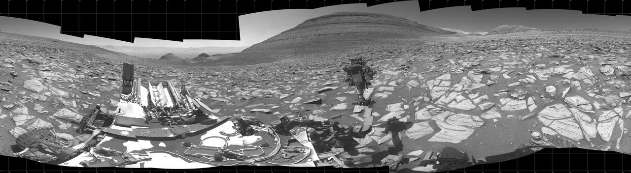 NASA's Curiosity Mars rover captured this 360-degree panorama using its black-and-white navigation cameras, or Navcams, at a location where it collected a sample from a rock nicknamed "Sequoia." This panorama was captured on Oct. 21 and 26, 2023, the 3,984th and 3,989th Martian days, or sols, of the mission. The sample from Sequoia marks the 39th hole that Curiosity drilled into the Martian surface. While the Perseverance rover collects intact rock cores, Curiosity's rock samples are powderized, then sprinkled into instruments within the rover's chassis. These instruments can provide highly detailed compositional data. Since 2014, Curiosity has been ascending the 3-mile-tall (5-kilometer-tall) Mount Sharp, a mountain with distinct layers that formed in different eras of ancient Martian history. By studying the differences between these layers, scientists are learning more about how the Martian climate – and especially its water – changed over time. https://photojournal.jpl.nasa.gov/catalog/PIA26047