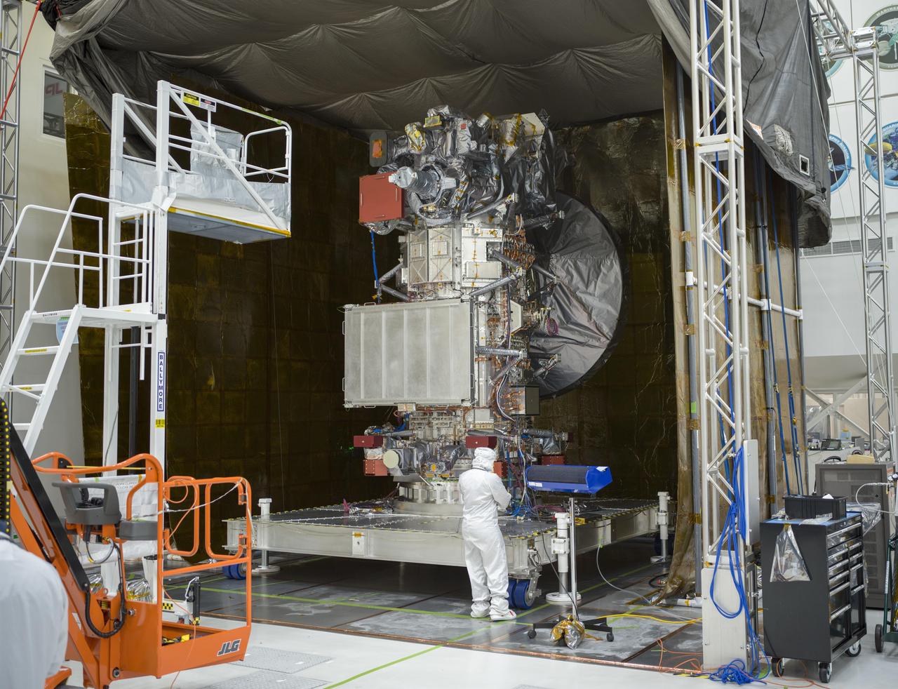  NASA's Europa Clipper spacecraft is seen in the main clean room of the Spacecraft Assembly Facility at the agency's Jet Propulsion Laboratory in Southern California on Jan. 19, 2024. The tent around the spacecraft was erected to support electromagnetic testing, which is designed to ensure the hardware will operate correctly in the electrical and magnetic conditions of space – and that the electrical and magnetic components that make up the spacecraft are compatible and don't interfere with one another.  Set to launch from Kennedy Space Center in Florida in October, Europa Clipper will arrive at the Jupiter system in 2030 and conduct about 50 flybys of the moon Europa. The mission's main science goal is to determine whether there are places below the icy surface of Europa that could support life. The mission's three main science objectives are to determine the thickness of the moon's ice shell and its surface interactions with the ocean below, to investigate its composition, and to characterize its geology. The mission's detailed exploration of Europa will help scientists better understand the astrobiological potential for habitable worlds beyond our planet.   https://photojournal.jpl.nasa.gov/catalog/PIA26061