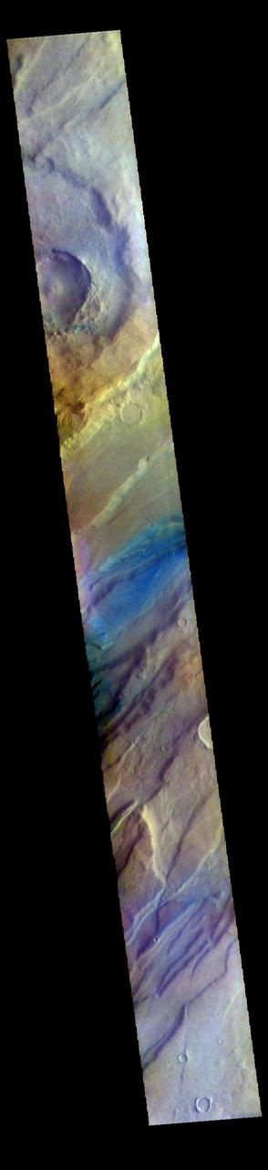 The THEMIS VIS camera contains 5 filters. The data from different filters can be combined in multiple ways to create a false color image. These false color images may reveal subtle variations of the surface not easily identified in a single band image. Today's false color image shows a small portion of Tempe Fossae. The linear features are tectonic graben. Graben are formed by extension of the crust and faulting. When large amounts of pressure or tension are applied to rocks on timescales that are fast enough that the rock cannot respond by deforming, the rock breaks along faults. In the case of a graben, two parallel faults are formed by extension of the crust and the rock in between the faults drops downward into the space created by the extension. The complete fossae system in almost 2000 km (1242 miles) long. The THEMIS VIS camera is capable of capturing color images of the Martian surface using five different color filters. In this mode of operation, the spatial resolution and coverage of the image must be reduced to accommodate the additional data volume produced from using multiple filters. To make a color image, three of the five filter images (each in grayscale) are selected. Each is contrast enhanced and then converted to a red, green, or blue intensity image. These three images are then combined to produce a full color, single image. Because the THEMIS color filters don't span the full range of colors seen by the human eye, a color THEMIS image does not represent true color. Also, because each single-filter image is contrast enhanced before inclusion in the three-color image, the apparent color variation of the scene is exaggerated. Nevertheless, the color variation that does appear is representative of some change in color, however subtle, in the actual scene. Note that the long edges of THEMIS color images typically contain color artifacts that do not represent surface variation. Orbit Number: 94065 Latitude: 46.5357 Longitude: 293.867 Instrument: VIS Captured: 2023-02-27 15:03 https://photojournal.jpl.nasa.gov/catalog/PIA26125
