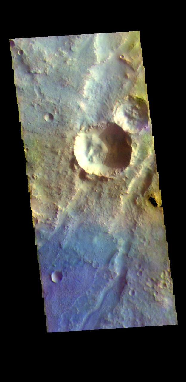 The THEMIS VIS camera contains 5 filters. The data from different filters can be combined in multiple ways to create a false color image. These false color images may reveal subtle variations of the surface not easily identified in a single band image. The linear depressions in today's false color image are part of Nili Fossae. Nili Fossae is a collection of curved faults and down-dropped blocks of crust between the faults. The "fossae," or graben, lie northeast of the large volcano Syrtis Major and northwest of the ancient impact basin Isidis Planitia. The troughs, which can be almost 500 meters (1,600 feet) deep , make concentric curves that follow the outline of Isidis Planitia. The graben likely formed as the crust sagged under the weight of lava flows filling the Isidis Planitia impact basin.  The THEMIS VIS camera is capable of capturing color images of the Martian surface using five different color filters. In this mode of operation, the spatial resolution and coverage of the image must be reduced to accommodate the additional data volume produced from using multiple filters. To make a color image, three of the five filter images (each in grayscale) are selected. Each is contrast enhanced and then converted to a red, green, or blue intensity image. These three images are then combined to produce a full color, single image. Because the THEMIS color filters don't span the full range of colors seen by the human eye, a color THEMIS image does not represent true color. Also, because each single-filter image is contrast enhanced before inclusion in the three-color image, the apparent color variation of the scene is exaggerated. Nevertheless, the color variation that does appear is representative of some change in color, however subtle, in the actual scene. Note that the long edges of THEMIS color images typically contain color artifacts that do not represent surface variation.  Orbit Number: 94834 Latitude: 21.5829 Longitude: 73.0022 Instrument: VIS Captured: 2023-05-01 22:33  https://photojournal.jpl.nasa.gov/catalog/PIA26136