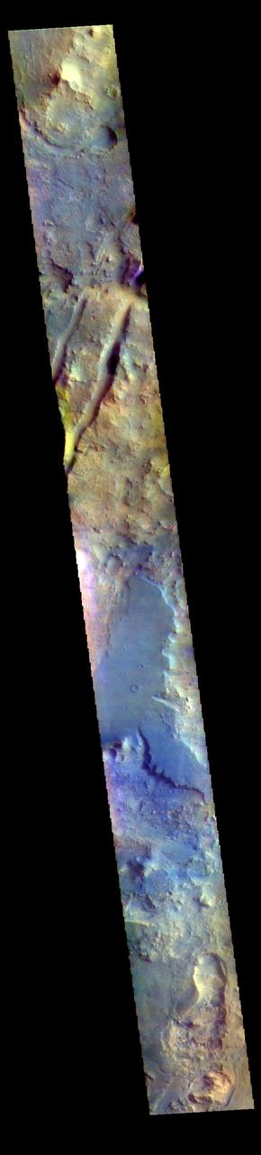 The THEMIS VIS camera contains 5 filters. The data from different filters can be combined in multiple ways to create a false color image. These false color images may reveal subtle variations of the surface not easily identified in a single band image. The linear depressions in today's false color image are part of Nili Fossae. Nili Fossae is a collection of curved faults and down-dropped blocks of crust between the faults. The "fossae," or graben, lie northeast of the large volcano Syrtis Major and northwest of the ancient impact basin Isidis Planitia. The troughs, which can be almost 500 meters (1,600 feet) deep , make concentric curves that follow the outline of Isidis Planitia. The graben likely formed as the crust sagged under the weight of lava flows filling the Isidis Planitia impact basin.  The THEMIS VIS camera is capable of capturing color images of the Martian surface using five different color filters. In this mode of operation, the spatial resolution and coverage of the image must be reduced to accommodate the additional data volume produced from using multiple filters. To make a color image, three of the five filter images (each in grayscale) are selected. Each is contrast enhanced and then converted to a red, green, or blue intensity image. These three images are then combined to produce a full color, single image. Because the THEMIS color filters don't span the full range of colors seen by the human eye, a color THEMIS image does not represent true color. Also, because each single-filter image is contrast enhanced before inclusion in the three-color image, the apparent color variation of the scene is exaggerated. Nevertheless, the color variation that does appear is representative of some change in color, however subtle, in the actual scene. Note that the long edges of THEMIS color images typically contain color artifacts that do not represent surface variation.  Orbit Number: 95071 Latitude: 17.8666 Longitude: 76.2766 Instrument: VIS Captured: 2023-05-21 10:52  https://photojournal.jpl.nasa.gov/catalog/PIA26151