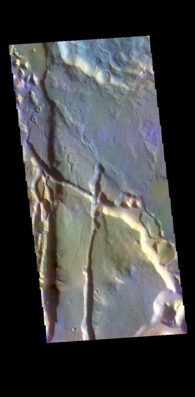 The THEMIS VIS camera contains 5 filters. The data from different filters can be combined in multiple ways to create a false color image. These false color images may reveal subtle variations of the surface not easily identified in a single band image. Today's false color image shows part of Cydonia Mensae. Cydonia Mensae is located in the region between the cratered highlands of northwestern Arabia Terra and the southern lowlands of Acidalia Planitia. This area contains many different landforms, including tectonic features, chaos terrain and impact craters. This VIS image shows a portion of chaos in the top left of the frame, and several tectonic depressions.  The THEMIS VIS camera is capable of capturing color images of the Martian surface using five different color filters. In this mode of operation, the spatial resolution and coverage of the image must be reduced to accommodate the additional data volume produced from using multiple filters. To make a color image, three of the five filter images (each in grayscale) are selected. Each is contrast enhanced and then converted to a red, green, or blue intensity image. These three images are then combined to produce a full color, single image. Because the THEMIS color filters don't span the full range of colors seen by the human eye, a color THEMIS image does not represent true color. Also, because each single-filter image is contrast enhanced before inclusion in the three-color image, the apparent color variation of the scene is exaggerated. Nevertheless, the color variation that does appear is representative of some change in color, however subtle, in the actual scene. Note that the long edges of THEMIS color images typically contain color artifacts that do not represent surface variation.  Orbit Number: 95074 Latitude: 35.0203 Longitude: 347.284 Instrument: VIS Captured: 2023-05-21 16:54  https://photojournal.jpl.nasa.gov/catalog/PIA26152