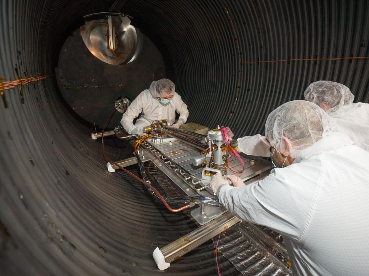 Engineers and technicians prepare NASA's Cold Operable Lunar Deployable Arm (COLDArm) robotic arm system for testing in a thermal vacuum chamber at the agency's Jet Propulsion Laboratory in Southern California in November 2023.  Successful testing in this chamber, which was reduced to minus 292 F (minus 180 C), demonstrates the arm can withstand the conditions it would face on the surface of the Moon.  To operate in the cold, COLDArm combines several key new technologies: gears made of bulk metallic glass, which require no wet lubrication or heating; cold motor controllers that don't need to be kept warm in an electronics box near the core of the spacecraft, and a cryogenic six-axis force torque sensor that lets the arm "feel" what it's doing and make adjustments.  A variety of attachments and small instruments could go on the end of the arm, including a 3D-printed titanium scoop that could be used for collecting samples from a celestial body's surface. Like the arm on NASA's InSight Mars lander, COLDArm could deploy science instruments to the surface.  https://photojournal.jpl.nasa.gov/catalog/PIA26162