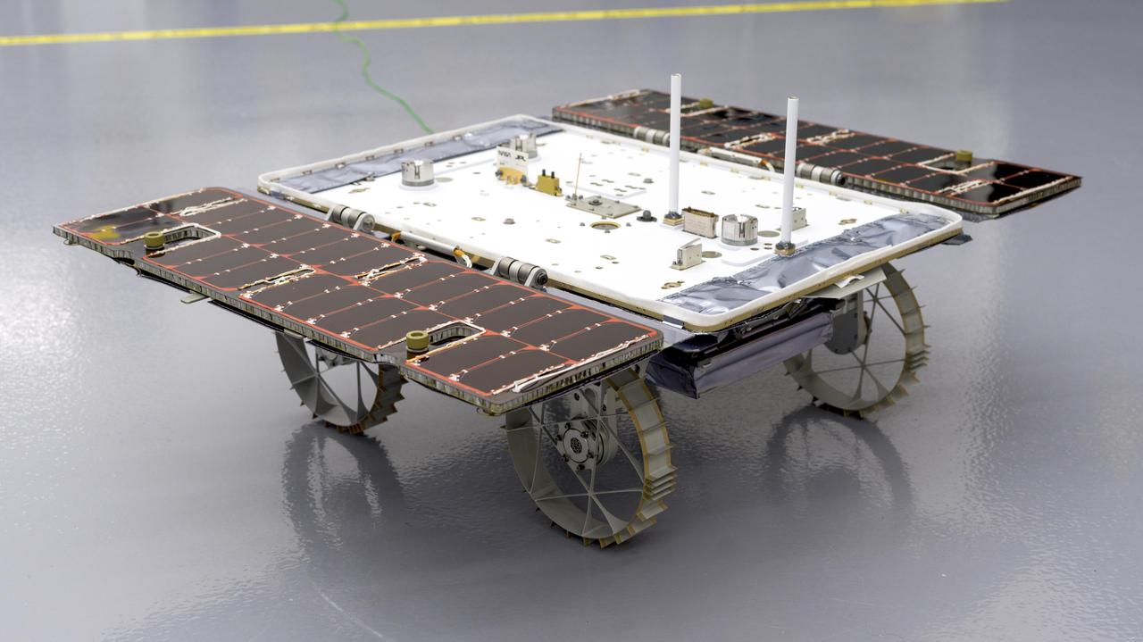 With its solar panels open, a small rover that is bound for the Moon sits in a clean room at NASA's Jet Propulsion Laboratory in Southern California on Jan. 26, 2024. This is one of three rovers – each about the size of a carry-on suitcase – that are part of the agency's CADRE (Cooperative Autonomous Distributed Robotic Exploration) technology demonstration.  CADRE is designed to show that a group of robotic spacecraft can work together as a team to accomplish tasks and record data autonomously – without explicit commands from mission controllers on Earth.  https://photojournal.jpl.nasa.gov/catalog/PIA26169