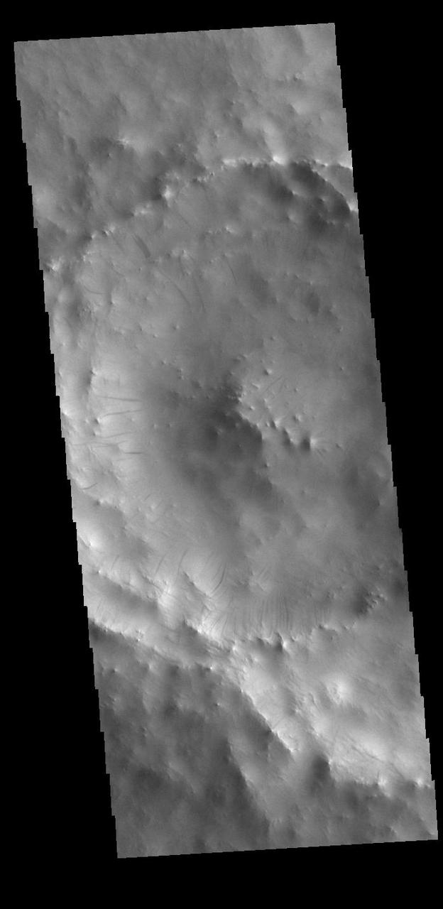 Dark streaks mark the inner rim of this unnamed crater in Terra Sabaea. There are several suggested mechanisms to form these features. Two of the mechanisms are that the dusty surface has been altered to reveal darker rock beneath from motion of downward moving dust avalanches, or the surface is darkening by fluid or other surface staining.  Orbit Number: 94910 Latitude: 12.9036 Longitude: 41.7337 Instrument: VIS Captured: 2023-05-08 04:41  https://photojournal.jpl.nasa.gov/catalog/PIA26216