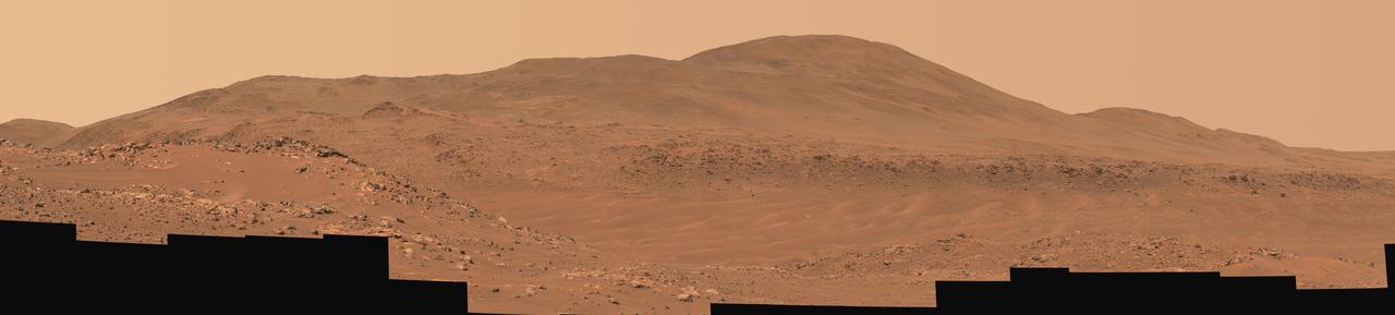 This natural-color mosaic showing NASA's Ingenuity Mars Helicopter at "Valinor Hills" was acquired by the agency's Perseverance Mars rover on Feb. 21, 2024, the 1,068th Martian day, or sol, of the mission. The helicopter – the first aircraft to achieve powered, controlled flight on another world – sits just left of center, a speck-like figure amid a field of sand ripples.  Ingenuity damaged its rotor blades during landing on its 72nd and final flight on Jan. 18, 2024. The helicopter team nicknamed the spot where the last flight concluded Valinor Hills after the fictional location in J.R.R. Tolkien's fantasy novels, which include "The Lord of the Rings" trilogy.  The 67 images that were stitched together to make this mosaic were captured from about 1,365 feet (415 meters) away by the rover's Mastcam-Z camera. This is a wider and more detailed view of Valinor Hills than was shown in a previously released six-image Mastcam-Z mosaic that was taken from farther away.  Arizona State University leads the operations of the Mastcam-Z instrument, working in collaboration with Malin Space Science Systems in San Diego, on the design, fabrication, testing, and operation of the cameras, and in collaboration with the Niels Bohr Institute of the University of Copenhagen on the design, fabrication, and testing of the calibration targets.  A key objective for Perseverance's mission on Mars is astrobiology, including the search for signs of ancient microbial life. The rover will characterize the planet's geology and past climate, pave the way for human exploration of the Red Planet, and be the first mission to collect and cache Martian rock and regolith (broken rock and dust).  Subsequent NASA missions, in cooperation with ESA (European Space Agency), would send spacecraft to Mars to collect these sealed samples from the surface and return them to Earth for in-depth analysis.  The Mars 2020 Perseverance mission is part of NASA's Moon to Mars exploration approach, which includes Artemis missions to the Moon that will help prepare for human exploration of the Red Planet.  https://photojournal.jpl.nasa.gov/catalog/PIA26237