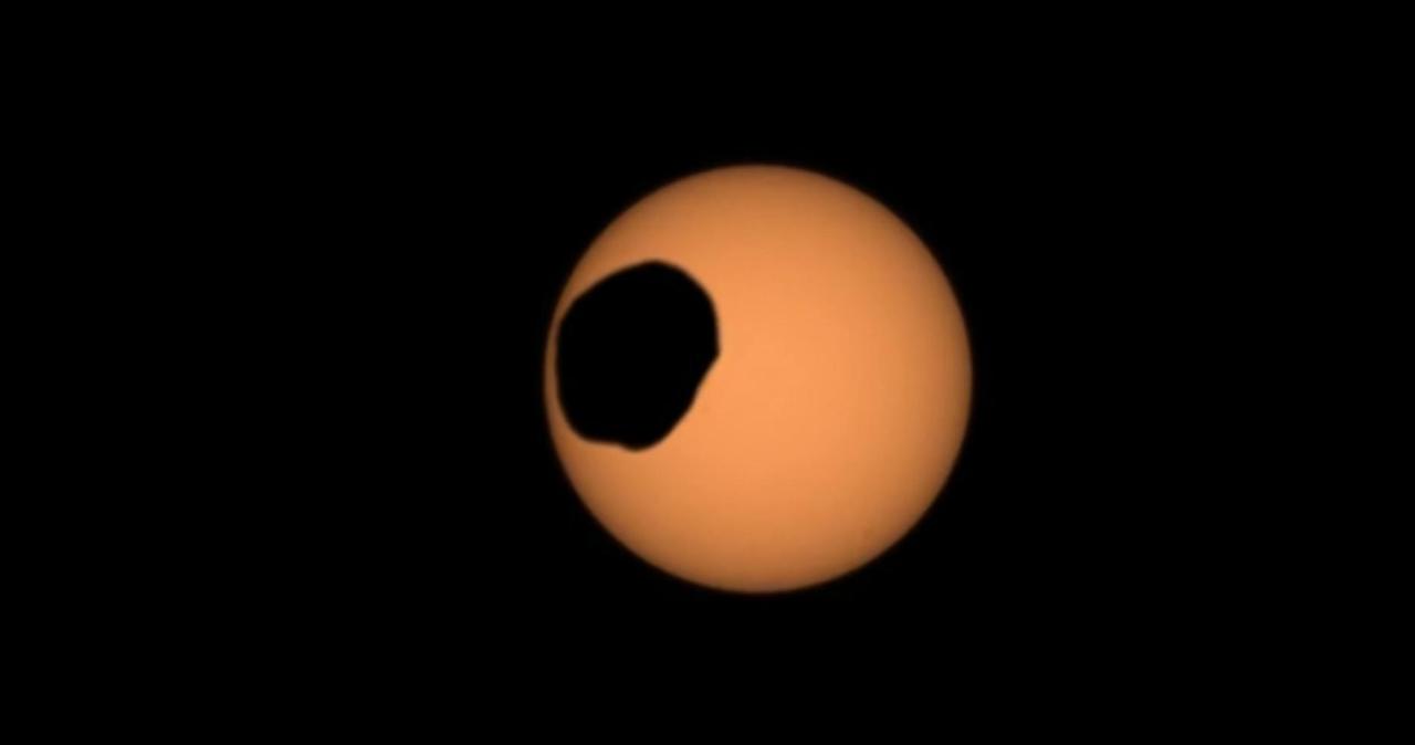 NASA's Perseverance Mars rover used its Mastcam-Z camera to capture the silhouette of Phobos, one of the two Martian moons, as it passed in front of the Sun on Feb. 8, 2024, the 1,056th Martian day, or sol, of the mission. This is one of several transits of Phobos that NASA's Mars rovers have captured. By comparing the various recordings, scientists can refine their understanding of the potato-shaped moon's orbit, learning how it's changing. Eons from now, Phobos' orbit is expected to eventually send the moon toward the Red Planet's surface.  The video shows the transit as it happened in real time.  Arizona State University leads the operations of the Mastcam-Z instrument, working in collaboration with Malin Space Science Systems in San Diego, on the design, fabrication, testing, and operation of the cameras, and in collaboration with the Niels Bohr Institute of the University of Copenhagen on the design, fabrication, and testing of the calibration targets.  A key objective for Perseverance's mission on Mars is astrobiology, including the search for signs of ancient microbial life. The rover will characterize the planet's geology and past climate, pave the way for human exploration of the Red Planet, and be the first mission to collect and cache Martian rock and regolith (broken rock and dust).  Subsequent NASA missions, in cooperation with ESA (European Space Agency), would send spacecraft to Mars to collect these sealed samples from the surface and return them to Earth for in-depth analysis.  The Mars 2020 Perseverance mission is part of NASA's Moon to Mars exploration approach, which includes Artemis missions to the Moon that will help prepare for human exploration of the Red Planet.  Video available at https://photojournal.jpl.nasa.gov/catalog/PIA26248