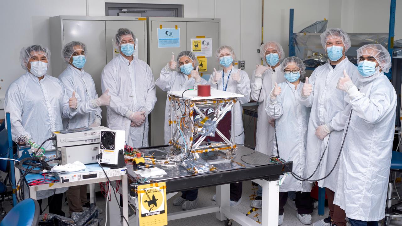 In a clean room at NASA's Jet Propulsion Laboratory in Southern California in March 2024, engineers and technicians pose with the agency's Farside Seismic Suite while the payload is readied for testing. The suite contains two instruments that will gather NASA's first seismic data from the Moon in nearly 50 years and take the first-ever seismic measurements from the Moon's far side. FSS will operate continuously for at least 4½ months, working through the long, cold lunar nights.  The two seismometers are packaged together with a large battery, a computer, and electronics inside a cube structure that's surrounded by several layers of insulation (the shiny material at center) and suspended within a protective outer cube, which is, in turn, covered with an insulating blanket. In this photo, the blanket has not yet been attached.  Members of the FSS integration team pictured are (from left) Salvador Ramirez, Asad Aboobaker, Nik Schwarz, Joanna Farias, Clara MacFarland, Frank Barone, Hsin-Yi Hao, Nicholas Roy-Steier, and Vik Singh.  https://photojournal.jpl.nasa.gov/catalog/PIA26342