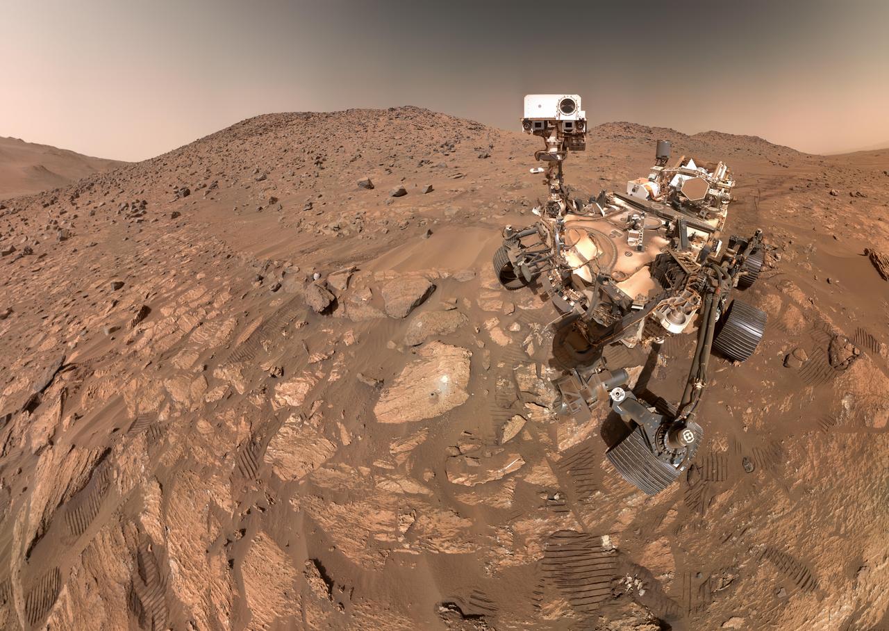 NASA's Perseverance Mars rover took this selfie on July 23, 2024, the 1,218th Martian day, or sol, of the mission. To the left of the rover near the center of the image is the arrowhead-shaped rock nicknamed "Cheyava Falls," which has features that may bear on the question of whether Mars was home to microscopic life in the distant past. The small dark hole in the rock is where Perseverance took a core sample, which is now in a sample tube stored in the rover's belly. The white patch to the right of the hole is where the rover used an abrasion tool to clear away the top surface, allowing science instruments to study the rock's composition. Measuring 3.2 feet by 2 feet (1 meter by 0.6 meters) and named after a Grand Canyon waterfall, Cheyava Falls lies at the northern edge of Neretva Vallis, an ancient river valley measuring a quarter-mile (400 meters) wide that was carved by water rushing into Jezero Crater long ago. The selfie is composed of 62 images taken by the WATSON (Wide Angle Topographic Sensor for Operations and eNgineering) camera on the end of the rover's robotic arm. The images were stitched together after being sent back to Earth. Animation available at https://photojournal.jpl.nasa.gov/catalog/PIA26344