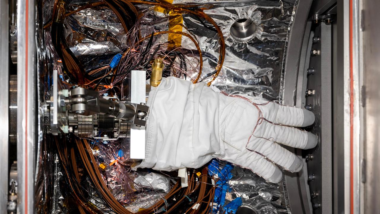       An astronaut glove designed for use during spacewalks on the International Space Station is prepared for thermal vacuum testing inside a chamber at NASA's Jet Propulsion Laboratory in Southern California on Nov. 1, 2023. The glove lies in a load lock, one of four small drawer-like chambers through which test materials are inserted into the larger main chamber of a facility called CITADEL (Cryogenic Ice Testing, Acquisition Development, and Excavation Laboratory).      The glove was tested at vacuum and temperatures as low as minus 352 degrees Fahrenheit (minus 213 degrees Celsius) – temperatures as frigid as those Artemis III astronauts could experience on the Moon's South Pole. Built to prepare potential future robotic spacecraft for the frosty, low-pressure conditions on ocean worlds like Jupiter's frozen moon Europa, CITADEL has also proven key to evaluating how astronaut gloves and boots hold up in extraordinary cold. The NASA Engineering and Safety Center spearheaded a glove testing campaign in CITADEL from October 2023 to March 2024.      Part of a spacesuit design called the Extravehicular Mobility Unit, the gloves tested in the chamber are the sixth version of a glove NASA began using in the 1980s. The testing in CITADEL showed that the legacy glove would not meet thermal requirements in the more challenging lunar South Pole environment.      In addition to spotting vulnerabilities with existing suits, the CITADEL experiments will help NASA develop this unique test capability and prepare criteria for standardized, repeatable, and inexpensive test methods for the next-generation lunar suit being built by Axiom Space.  https://photojournal.jpl.nasa.gov/catalog/PIA26430