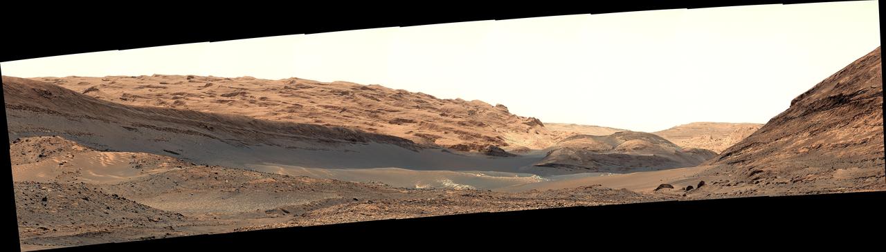 NASA's Curiosity Mars rover captured this view of a geological region called the Yardang Unit using its Mast Camera, or Mastcam, on Nov. 2, 2024, the 4,352nd Martian day, or sol, of the mission. This mosaic is made up of 18 images that were stitched together after being sent back to Earth. The color has been adjusted to match lighting conditions as the human eye would see them on Earth.  A yardang is an elongated ridge created by wind erosion. The Yardang Unit is a layer found at the uppermost reaches of the foothills at the base of Mount Sharp, a 3-mile-tall (5-kilometer-tall) mountain that Curiosity has been ascending since 2014. The color, texture, and tilt of the layers in the Yardang Unit make it distinct from lower layers on the mountain. Mount Sharp is an exciting place for scientists to study because it's made up of a number of layers, each representing a distinct era in the climate of ancient Mars.  https://photojournal.jpl.nasa.gov/catalog/PIA26472