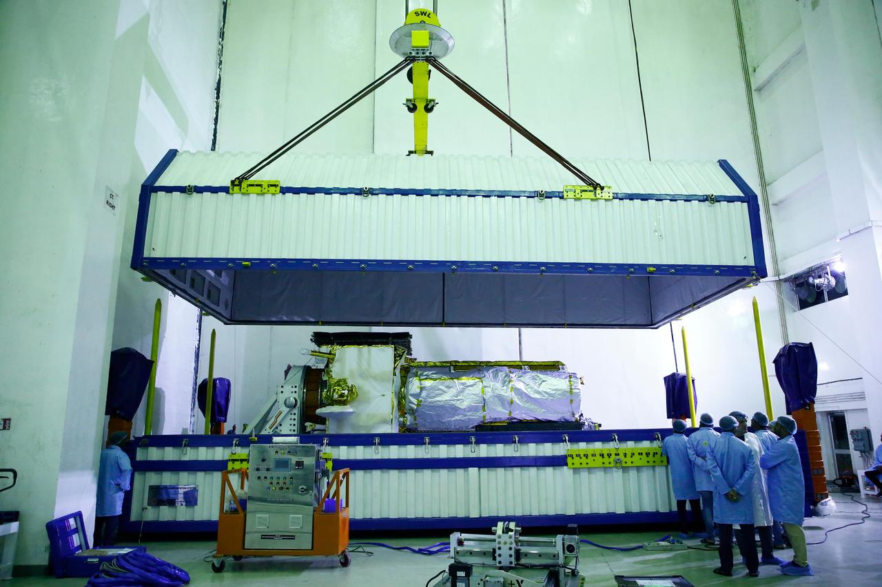 The lid of a specialized container is lifted to reveal NISAR, the Earth-observing radar satellite jointly developed by NASA and the Indian Space Research Organisation (ISRO), shortly after the spacecraft's arrival at ISRO's Satish Dhawan Space Centre in Sriharikota on India's southeastern coast on May 16, 2025.  The NISAR (NASA-ISRO Synthetic Aperture Radar) satellite had departed about two days earlier from the ISRO Satellite Integration and Test Establishment (ISITE) in Bengaluru. At ISITE, engineers from the Indian space agency and NASA's Jet Propulsion Laboratory in Southern California, which manages the mission for NASA, had worked together since March 2023 to bring together components and assemble the satellite. They also tested the spacecraft to ensure it can withstand the rigors of launch and function properly in orbit.  In the early morning of May 14, crews placed the satellite in the specialized container and transported it about 220 miles (360 kilometers) by truck to the space center. Prior to launch the satellite will be encapsulated in its payload fairing and mounted atop an ISRO Geosynchronous Launch Vehicle Mark II rocket.  In orbit, NISAR will collect an unprecedented amount of information about change on our home planet. It will scan nearly all of Earth's land and ice surfaces twice every 12 days, providing insights into the growth and retreat of ice sheets, sea ice, and glaciers, the deformation of the planet's crust due to natural hazards, as well as natural and human-caused changes to its terrestrial ecosystems, including forests and wetlands.  https://photojournal.jpl.nasa.gov/catalog/PIA26500