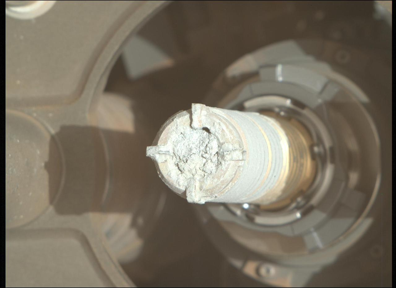 This image shows a cylinder of rock the size of a piece of classroom chalk inside the drill of NASA's Perseverance Mars rover. The sample, dubbed "Green Gardens," was taken from a rock called "Tablelands" on the rim of Mars' Jezero Crater. The image was captured by the Mastcam-Z instrument on Feb. 16, 2025, the 1,420th Martian day, or sol, of the mission.  Each core the rover takes is about 0.5 inches (13 millimeters) in diameter and 2.4 inches (60 millimeters) long.  Data from the rover's instruments indicates that Tablelands is made almost entirely of serpentine minerals, which form when large amounts of water react with iron- and magnesium-bearing minerals in igneous rocks. During this process, called serpentinization, the rock's original structure and mineralogy change, often causing it to expand and fracture. Byproducts of the process sometimes include hydrogen gas, which can lead to the generation of methane in the presence of carbon dioxide. On Earth, such rocks can support microbial communities.  Arizona State University leads the operations of the Mastcam-Z instrument, working in collaboration with Malin Space Science Systems in San Diego, on the design, fabrication, testing, and operation of the cameras, and in collaboration with the Niels Bohr Institute of the University of Copenhagen on the design, fabrication, and testing of the calibration targets.  A key objective for Perseverance's mission on Mars is astrobiology, including the search for signs of ancient microbial life. The rover will characterize the planet's geology and past climate, pave the way for human exploration of the Red Planet, and be the first mission to collect and cache Martian rock and regolith (broken rock and dust).  Subsequent NASA missions, in cooperation with ESA (European Space Agency), would send spacecraft to Mars to collect these sealed samples from the surface and return them to Earth for in-depth analysis.  The Mars 2020 Perseverance mission is part of NASA's Mars Exploration Program (MEP) portfolio and the agency's Moon to Mars exploration approach, which includes Artemis missions to the Moon that will help prepare for human exploration of the Red Planet.  https://photojournal.jpl.nasa.gov/catalog/PIA26529