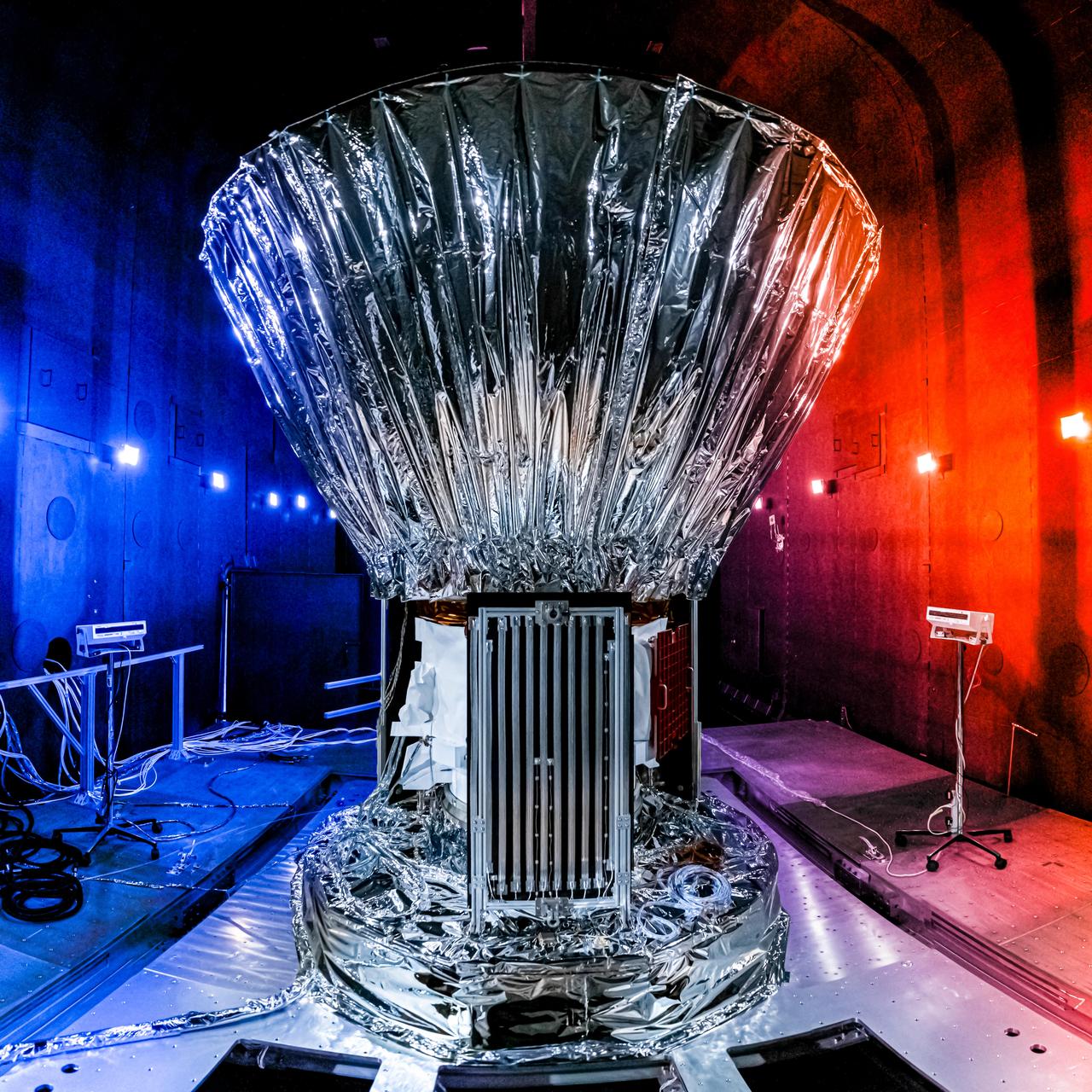 NASA's SPHEREx observatory is installed in the Titan Thermal Vacuum (TVAC) test Chamber at BAE Systems in Boulder, Colorado, in June 2024. As part of the test setup, the spacecraft and photon shield are covered in multilayer insulation and blankets and surrounded by ground support equipment.  Short for Spectro-Photometer for the History of the Universe, Epoch of Reionization and Ices Explorer, SPHEREx will create a map of the cosmos like no other. Using a technique called spectroscopy to image the entire sky in 102 wavelengths of infrared light, SPHEREx will gather information about the composition of and distance to millions of galaxies and stars. With this map, scientists will study what happened in the first fraction of a second after the big bang, how galaxies formed and evolved, and the origins of water in planetary systems in our galaxy.  https://photojournal.jpl.nasa.gov/catalog/PIA26541