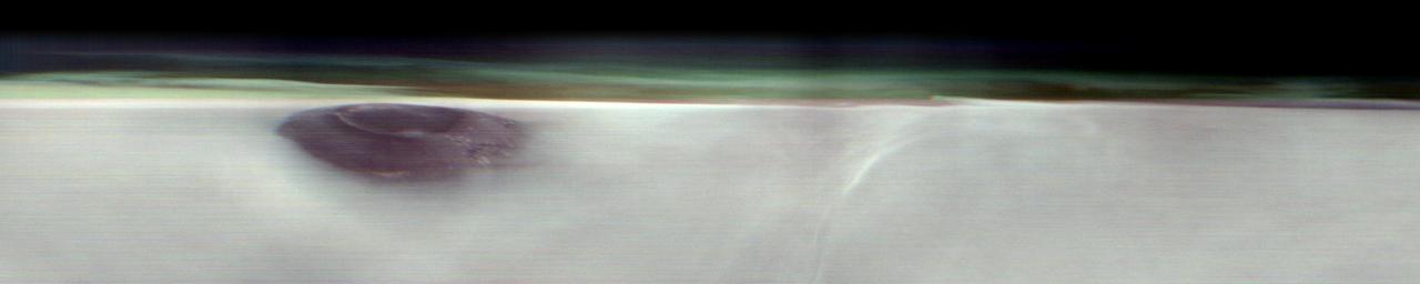 NASA's 2001 Mars Odyssey orbiter used its Thermal Emission Imaging System (THEMIS) to capture this view of Arsia Mons, an ancient volcano, while studying the Red Planet's atmosphere, which appears here as a greenish haze above the scene. THEMIS took the image well before dawn on May 2, 2025. The image has been stretched and brightened to improve contrast and processed to remove instrument noise.  The southernmost of the three Tharsis volcanoes, Arsia Mons is 270 miles (450 kilometers) in diameter and almost 12 miles (20 kilometers) high. For comparison, the largest volcano on Earth is Mauna Loa, which measures 75 miles (121 kilometers) in diameter and roughly 6 miles (9 kilometers) high from its base on the seafloor.  A large crater known as a caldera, produced by massive volcanic explosions and collapse, is located at the summit of all of the Tharsis volcanoes. At 72 miles (120 kilometers) wide, the Arsia Mons summit caldera is larger than many volcanoes on Earth.  This type of image shows Mars' "limb," the edge of the planet's horizon. By flipping on its side while in orbit, Odyssey can point THEMIS head-on at the limb and capture images of the Martian atmosphere. This unique view allows scientists to see the structure and shape of dust and water-ice cloud layers and observe how they change over the course of seasons. Understanding Mars' clouds is particularly important for understanding Martian weather and how phenomena like dust storms occur.  This is THEMIS' fourth limb observation since it began pursuing this new kind of science in 2023. When possible, the camera's team has tried to include an interesting surface feature such as Olympus Mons, the tallest volcano in the solar system.  https://photojournal.jpl.nasa.gov/catalog/PIA26557