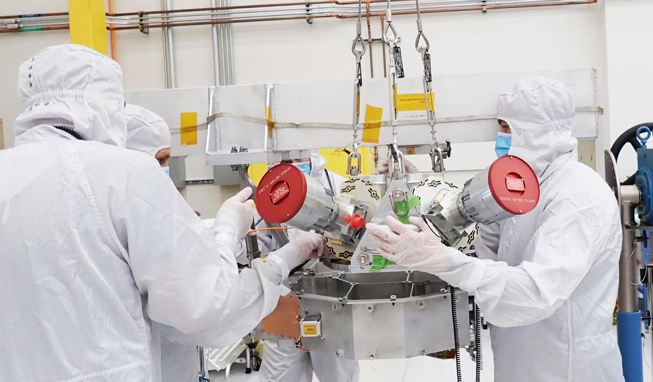 Engineers on NASA's Europa Clipper mission work with a piece of hardware called star trackers before they are integrated onto the spacecraft in a clean room at the agency's Jet Propulsion Laboratory in Southern California in 2022. The star trackers are seen here with red covers to protect their lenses.  The star trackers, formally called stellar reference units, look for stars and use them like a compass to help mission controllers know the exact orientation of the spacecraft – information critical for pointing telecommunications antennas toward Earth and sending data back and forth smoothly.  The spacecraft launched from the agency's Kennedy Space Center in Florida on Oct. 14, 2024.  Europa Clipper's three main science objectives are to determine the thickness of the moon's icy shell and its interactions with the ocean below, to investigate its composition, and to characterize its geology. The mission's detailed exploration of Europa will help scientists better understand the astrobiological potential for habitable worlds beyond our planet.  https://photojournal.jpl.nasa.gov/catalog/PIA26562