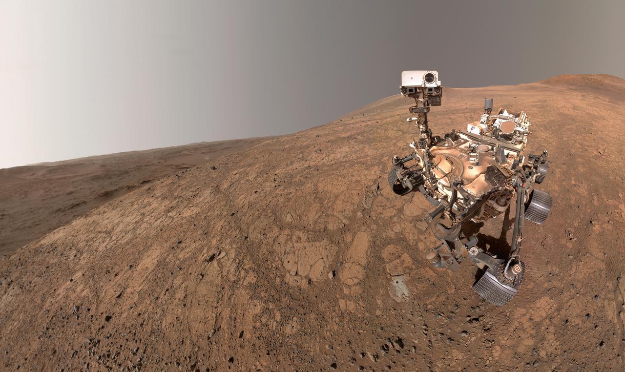 NASA's Perseverance rover took this selfie on May 10, 2025, marking its 1,500th Martian day, or sol, exploring the Red Planet. A dust devil twirls in the background, about 3 miles (5 kilometers) away, to the left of the rover. The small dark hole in the rock in front of the rover is the borehole made when Perseverance collected a sample dubbed "Bell Island."  The selfie is composed of 59 images taken by the WATSON (Wide Angle Topographic Sensor for Operations and eNgineering) camera on the end of the rover's robotic arm. The images were stitched together after being sent back to Earth. The selfie was further processed to improve visual contrast and accentuate color differences.  https://photojournal.jpl.nasa.gov/catalog/PIA26574