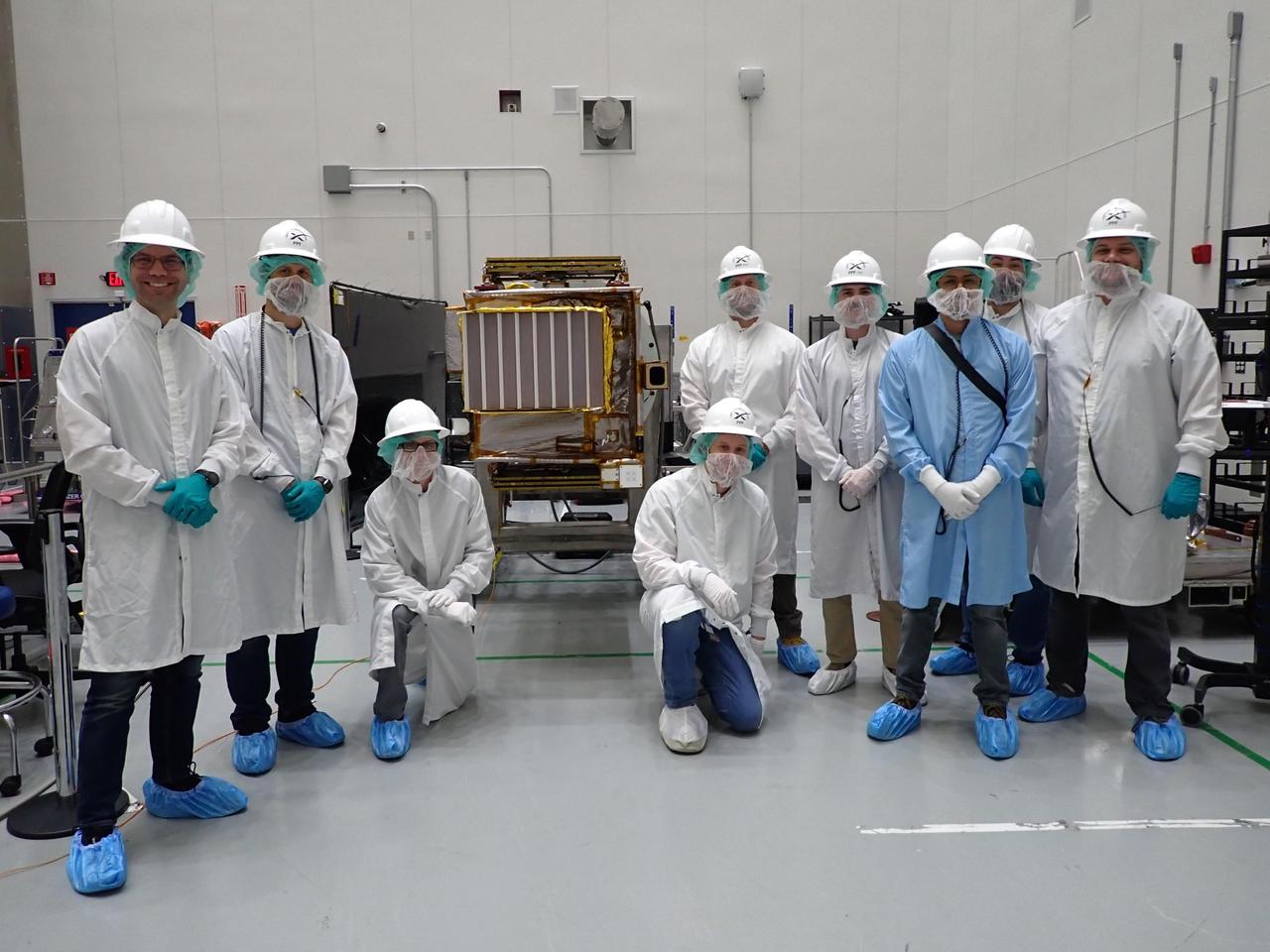 Members of NASA's Lunar Trailblazer team pose with the spacecraft at SpaceX's payload processing facility at NASA's Kennedy Space Center in Florida in early February 2025. The grated radiator of the High-resolution Volatiles and Minerals Moon Mapper (HVM³) instrument is facing the camera. Pictured, from left: Andrew Klesh, Jeff Pyle, Ryan Kressler, Willie Parker, Jon Newman, Alex Sugarman, David Rodriquez, Chris Calamateos-Brown, and David Hobbs.  https://photojournal.jpl.nasa.gov/catalog/PIA26581